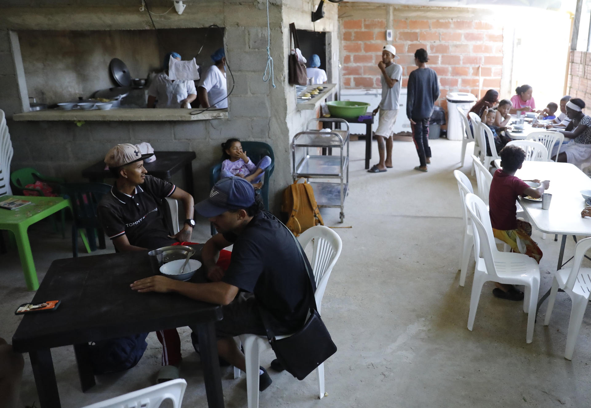 Fotografía del 29 de agosto de 2025 de migrantes venezolanos recibiendo alimentos en un comedor comunitario en Necoclí (Colombia). EFE/ Juan Diego López
