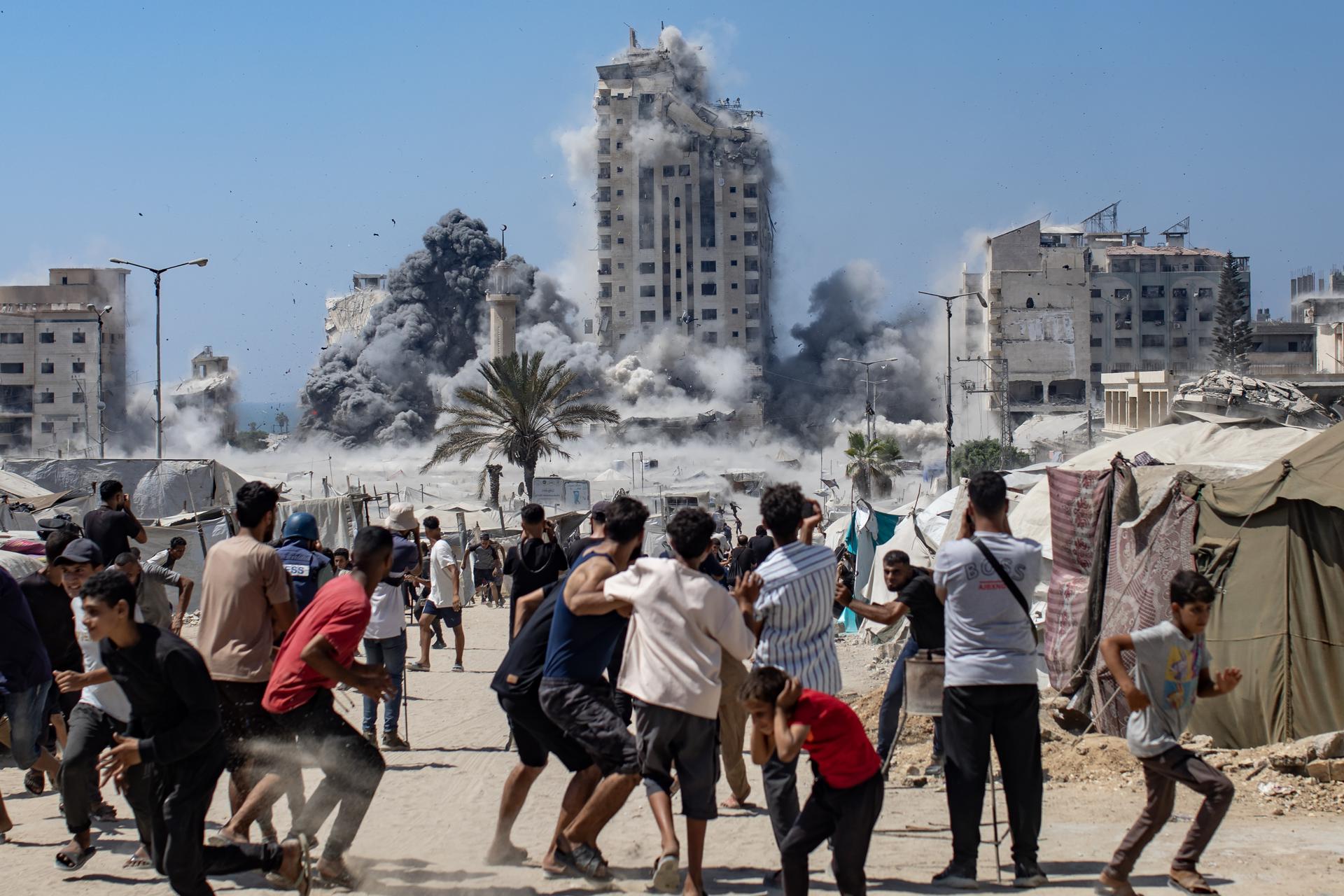 Palestinos reaccionan al humo que se eleva desde la Torre Mushtaha tras un ataque aéreo israelí en el oeste de la ciudad de Gaza, Franja de Gaza, el 5 de septiembre de 2025. EFE/HAITHAM IMAD