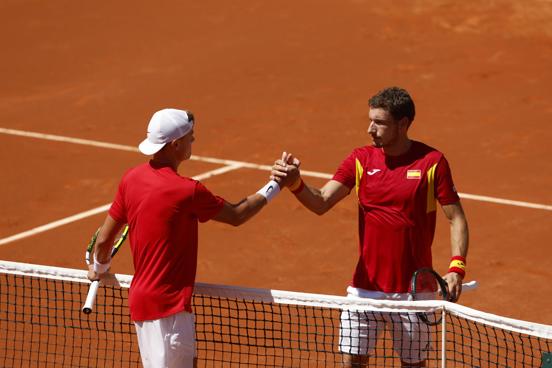 El tenista danés Holger Rune (i) es felicitado por el español Pablo Carreño tras ganar su partido de la segunda ronda clasificatoria de la Copa Davis, este sábado en el club de tenis Puente Romano en Marbella. Rune ganó por 5-7 y 3-6. EFE/ Jorge Zapata
