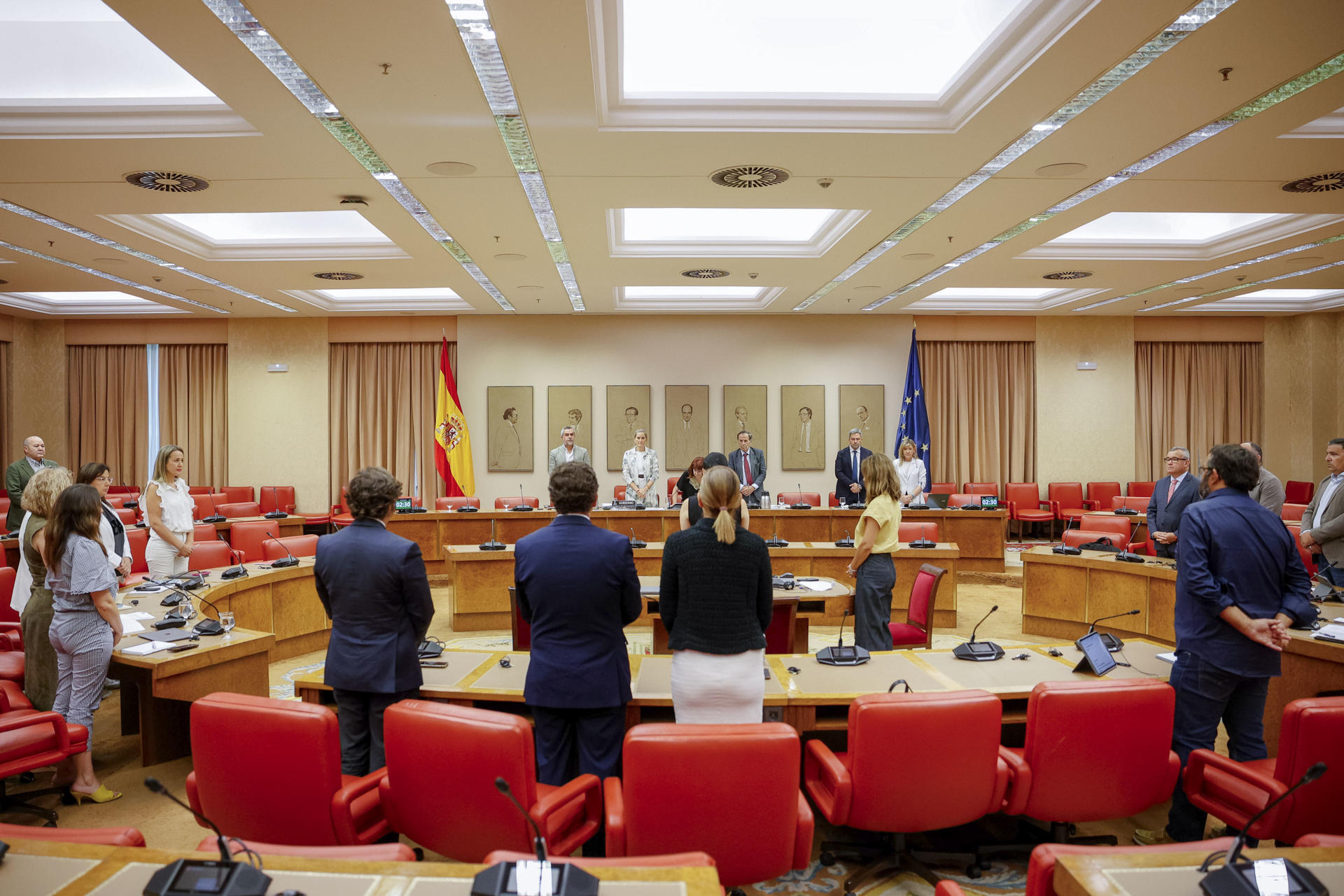 La vicepresidenta tercera y ministra para la Transición Ecológica y el Reto Demográfico, Sara Aagesen (c, al fondo), junto al resto de los miembros de la comisión, guarda un minuto de silencio por las víctimas de los incendios momentos antes de comparecer este viernes en el Congreso para informar sobre la actuación de su departamento en relación a los incendios forestales. EFE/ Daniel González