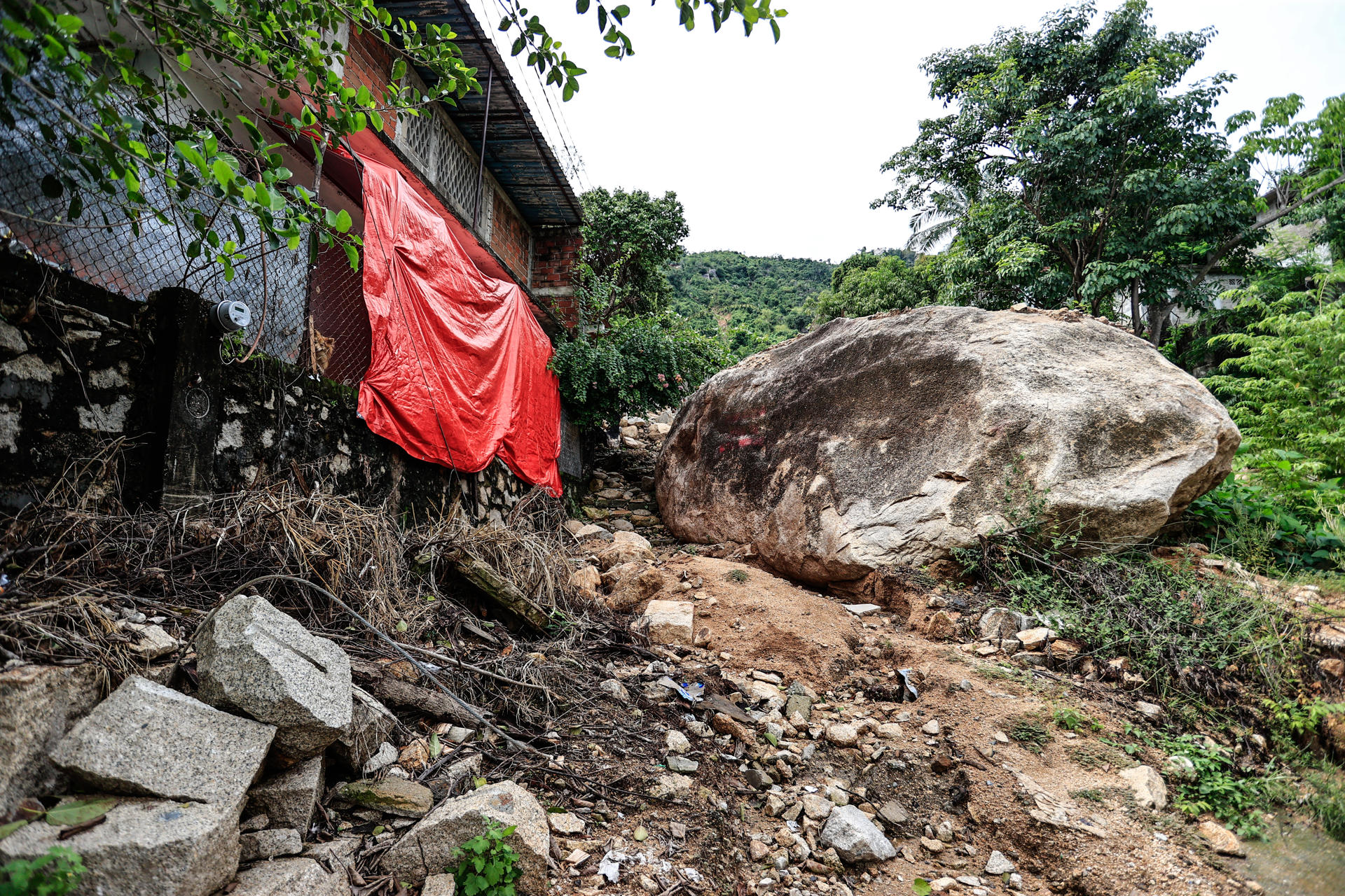Fotografía de una roca junto a una vivienda un año después del huracán John en el balneario de Acapulco, este martes en Guerrero (México). EFE/ David Guzmán
