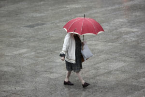 Una ujer se protege de la lluvia en una foto de archivo.. EFE/ Jesus Diges
