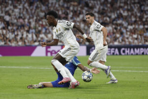 El delantero brasileño del Real Madrid Vinicius Jr. intenta escaparse con el balón durante el partido de la primera jornada de la Liga de Campeones que Real Madrid y Olympique de Marsella disputan en el estadio Santiago Bernabéu. EFE/Sergio Pérez