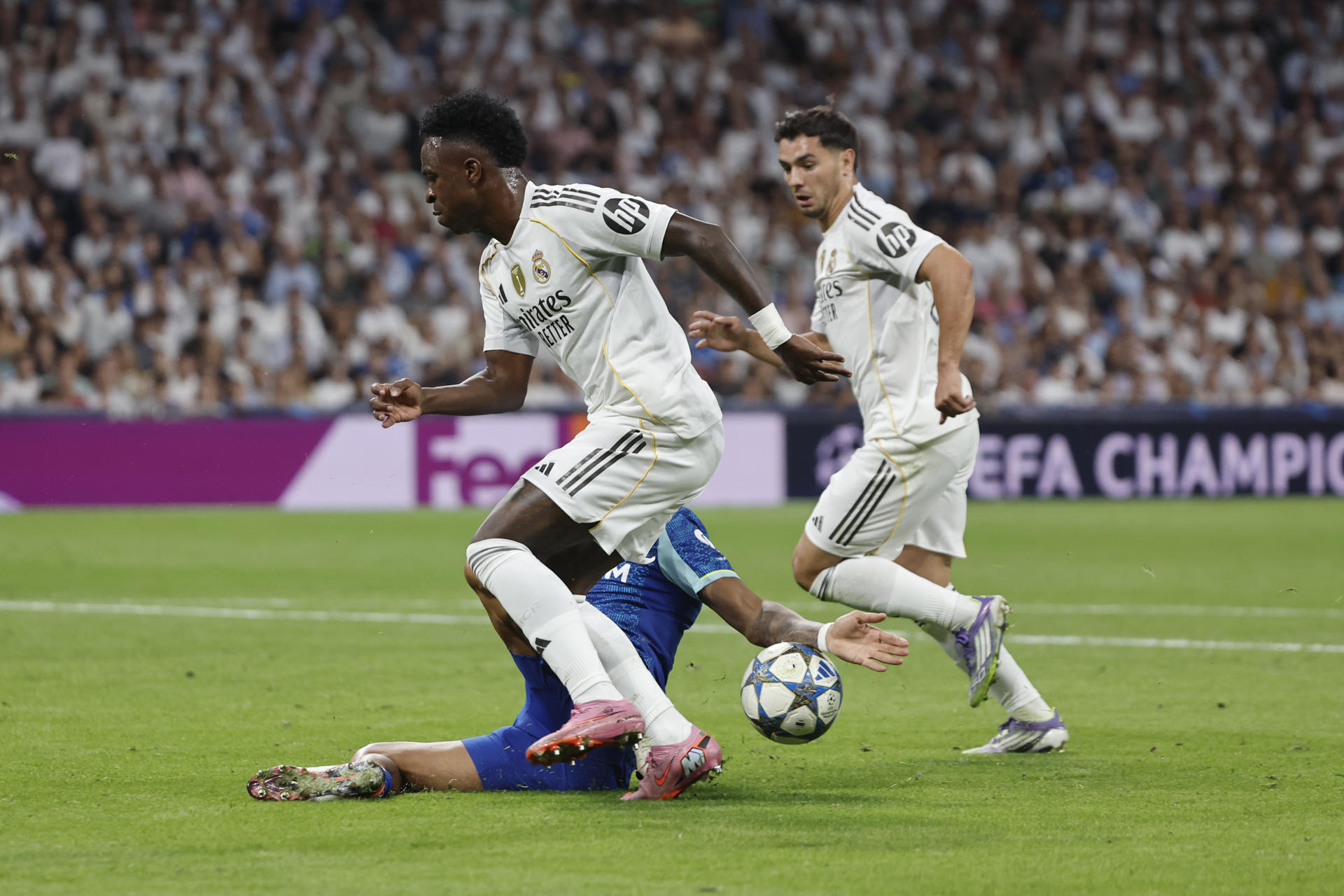 El delantero brasileño del Real Madrid Vinicius Jr. intenta escaparse con el balón durante el partido de la primera jornada de la Liga de Campeones que Real Madrid y Olympique de Marsella disputan en el estadio Santiago Bernabéu. EFE/Sergio Pérez