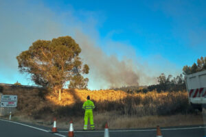 Vista del incendio en el que trabajan efectivos de bomberos y del Plan Infoca en Higuera de la Sierra (Huelva), que se ha declarado en torno a las 3.00 de la madrugada tras comenzar a arder un camión, y mantiene cortada la principal carretera entre la zona norte de la provincia y Portugal, la N-433. EFE/ Fermín Cabanillas