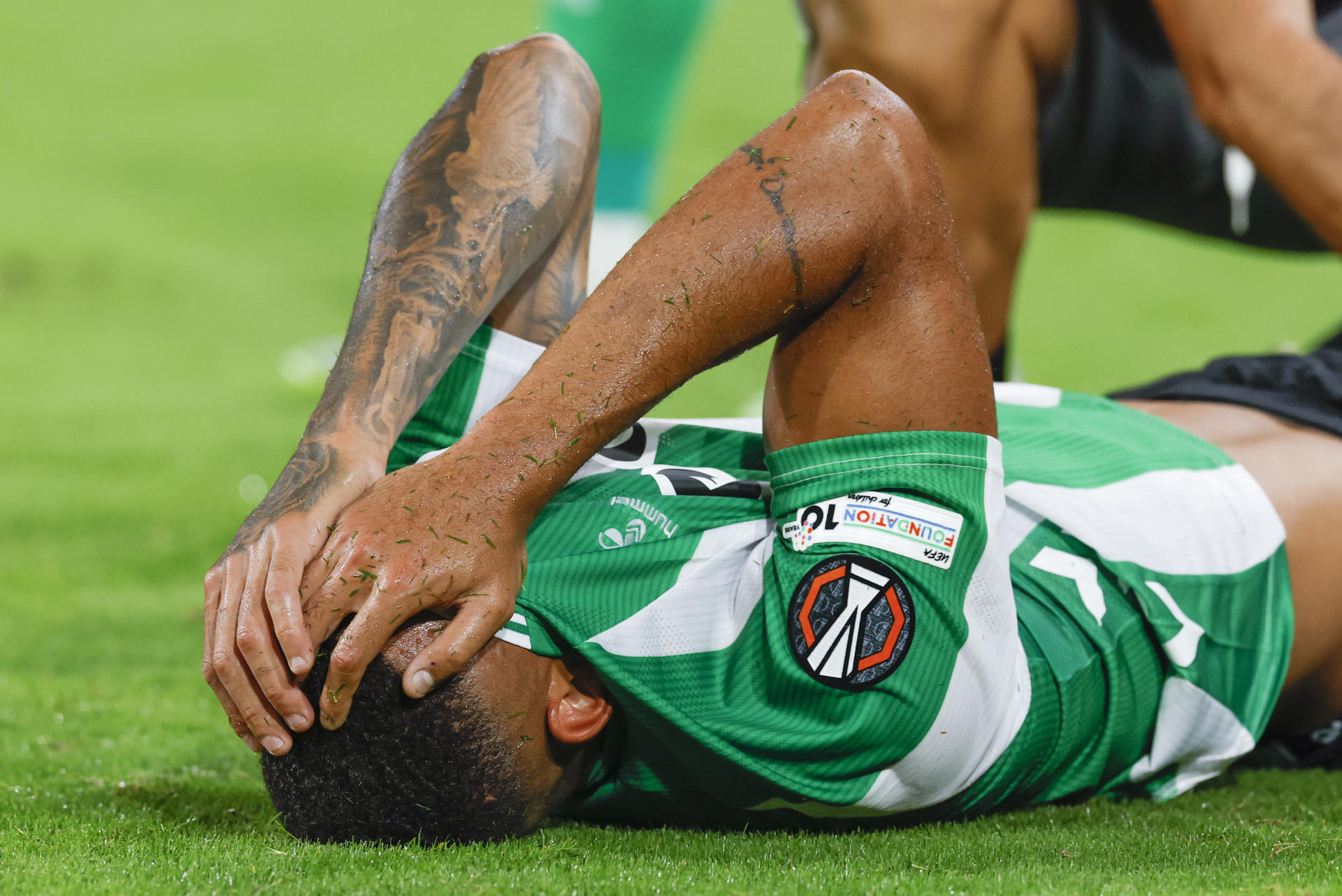 El defensa brasileño del Betis, Natan, se duele en el terreno de juego tras sufrir una entrada durante el encuentro correspondiente a la fase regular de la Liga Europa que disputan hoy miércoles Betis y Nottingham Forest en el estadio de La Cartuja, en Sevilla. EFE / Julio Muñoz.
