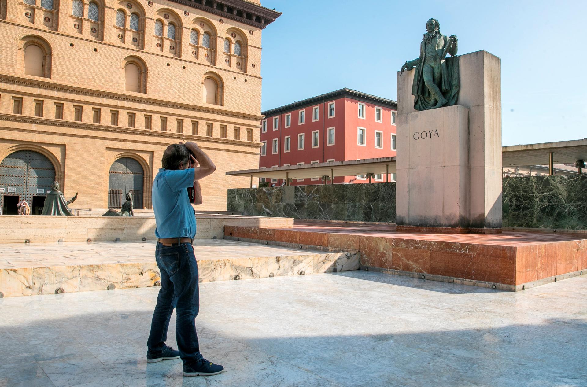 Un hombre fotografía una estatua de Goya en la Plaza del Pilar de Zaragoza. EFE/Javier Cebollada