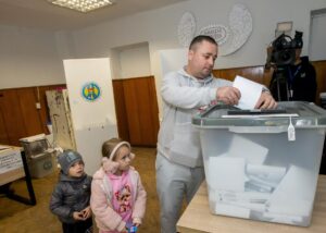 Un votante, acompañado por sus hijos, participa en Chisinau en las elecciones parlamentarias moldavas EFE/EPA/Dumitru Doru