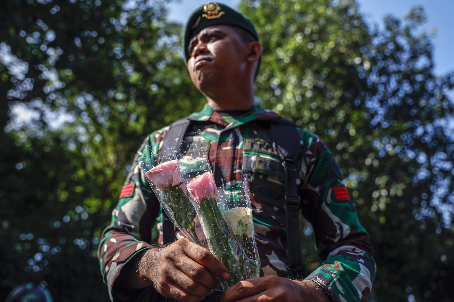 YAKARTA (Indonesia), 02/09/2025.- Un militar sostiene flores entregadas por manifestantes durante una congregación por la paz, después de días de violentas protestas en Indonesia que dejan al menos 10 muertos. EFE/EPA/MAST IRHAM