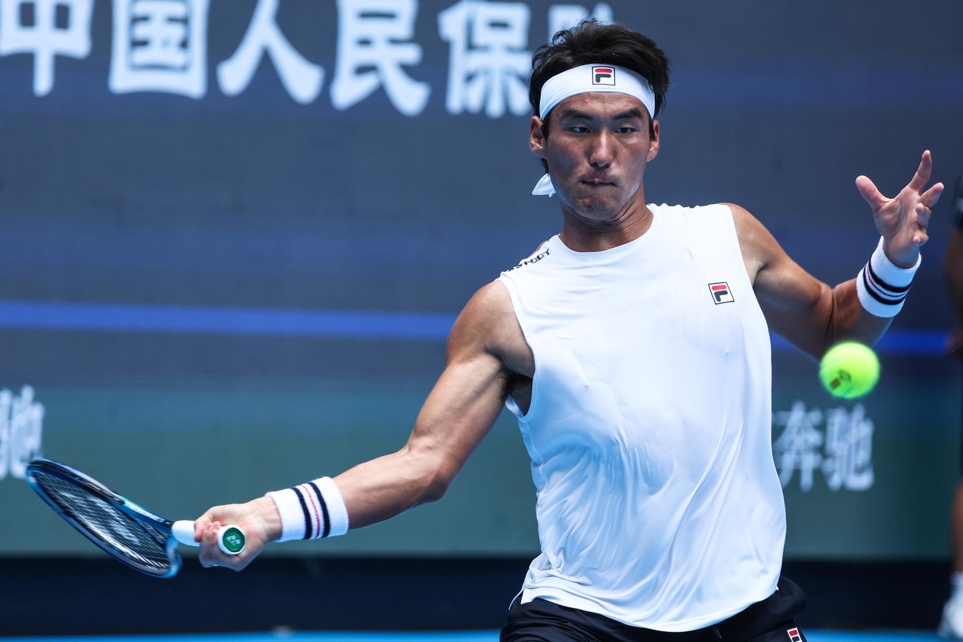 El tenista chino Yunchaokete Bu en acción durante el partido de individuales masculinos de la ronda de 32 contra Alex de Minaur de Australia en el Abierto de China. EFE/EPA/WU HAO
