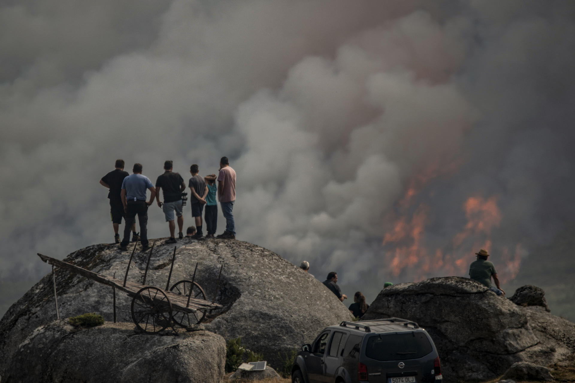 Varias personas observan el incendio forestal en Avión, en Ourense, en agosto pasado. EFE/Brais Lorenzo