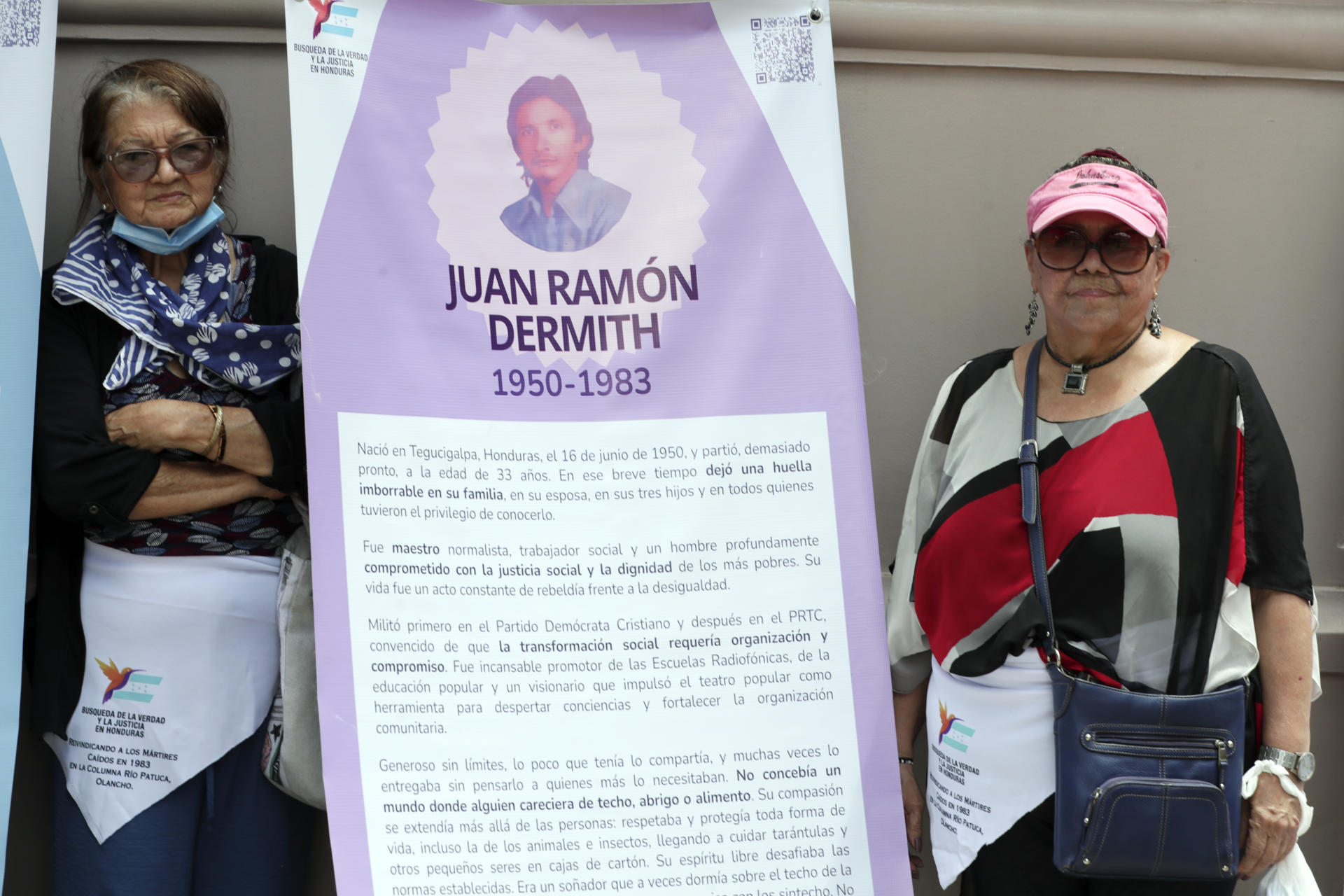 Fotografía del 22 de septiembre de 2025 que muestra a la viuda del miembro de la columna guerrillera Juan Ramón Dermith, Edna Salazar (i), y a su hermana, Miriam Dermith (d), posando junto a un cartel en Tegucigalpa (Honduras). EFE/STR
