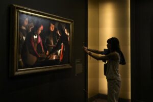 Una mujer fotografía el cuadro "Los jugadores de dados", del pintor francés Georges de La Tour, en la exposición sobre la obra de este artista organizada en el Museo Jacquemart André de París.EFE/EPA/Teresa Suarez