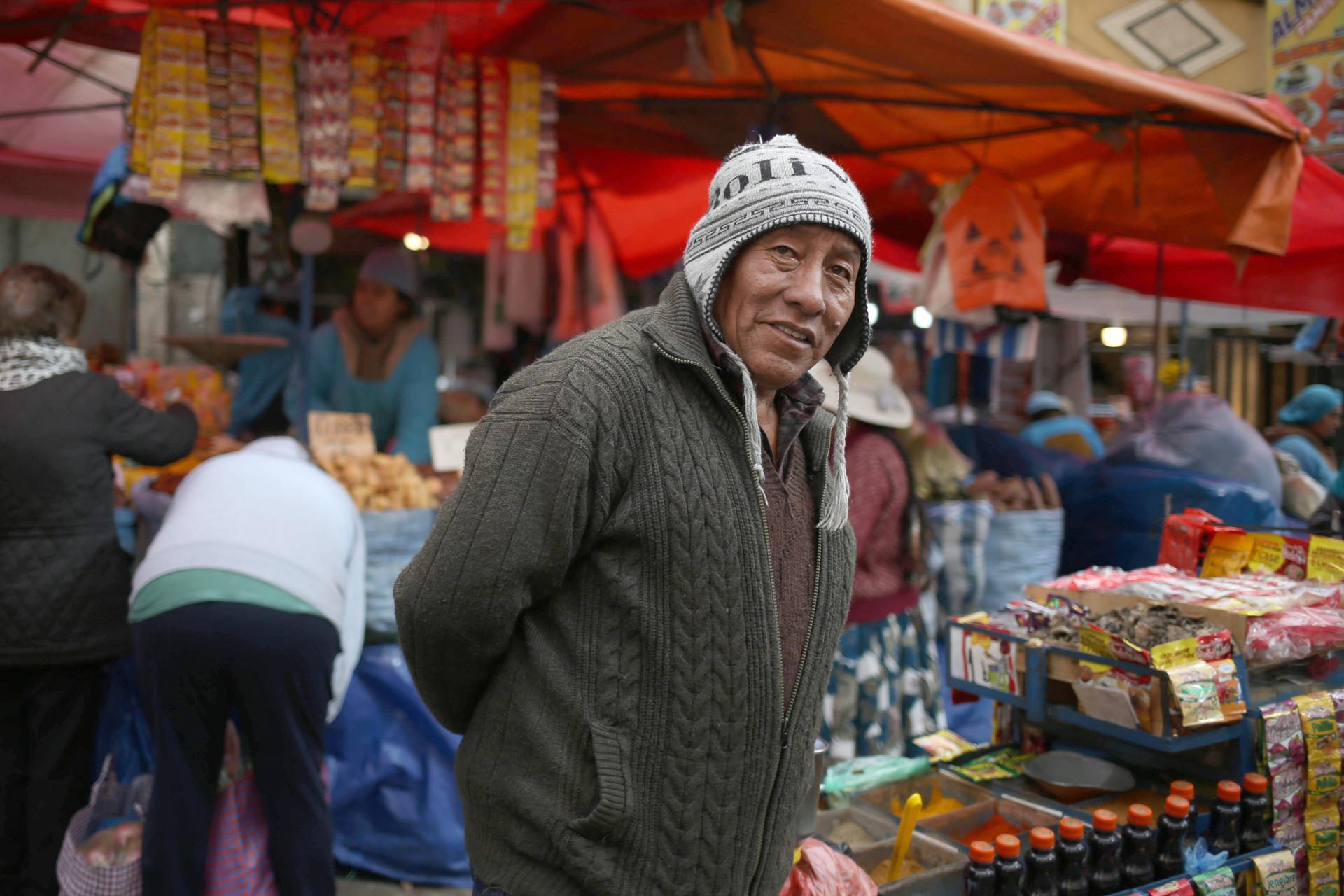 Un hombre aimara camina frente a un mercado popular este 3 de septiembre de 2025, en La Paz (Bolivia). EFE/ Luis Gandarillas