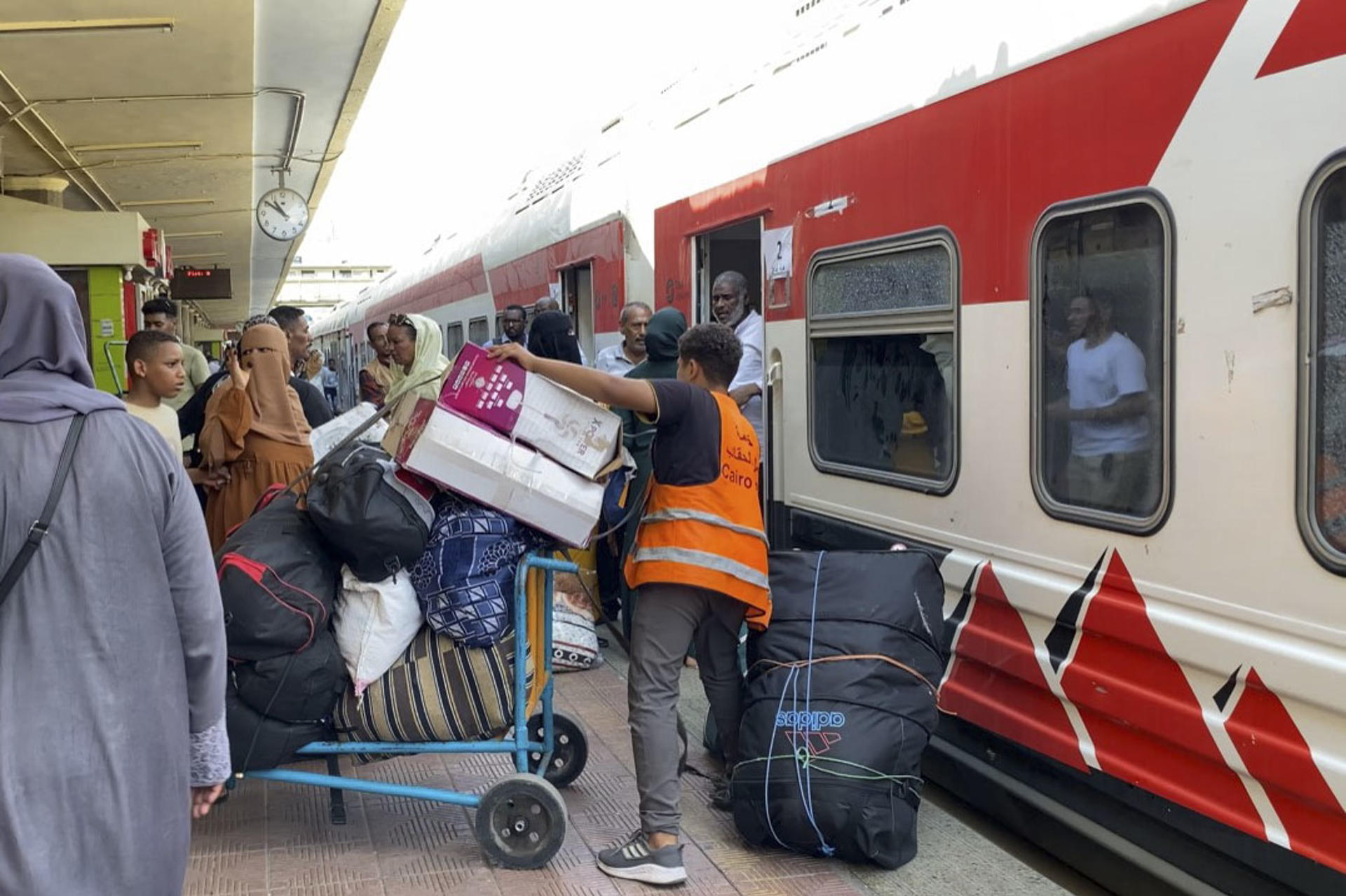 Un joven asistente descarga equipaje de una carretilla en el andén para introducirlo en el vagón del tren reservado para que los refugiados sudaneses retornen a su país desde El Cairo. En la céntrica estación de ferrocarril de Ramsés, en El Cairo, el bullicio habitual se mezcla con aires de despedida y esperanza. Alrededor de 940 refugiados sudaneses, cargados con grandes bultos y maletas con pertenencias y recuerdos acumulados durante su exilio, se preparan para abordar el tren que les llevará de regreso a su país. EFE/Rosa Soto