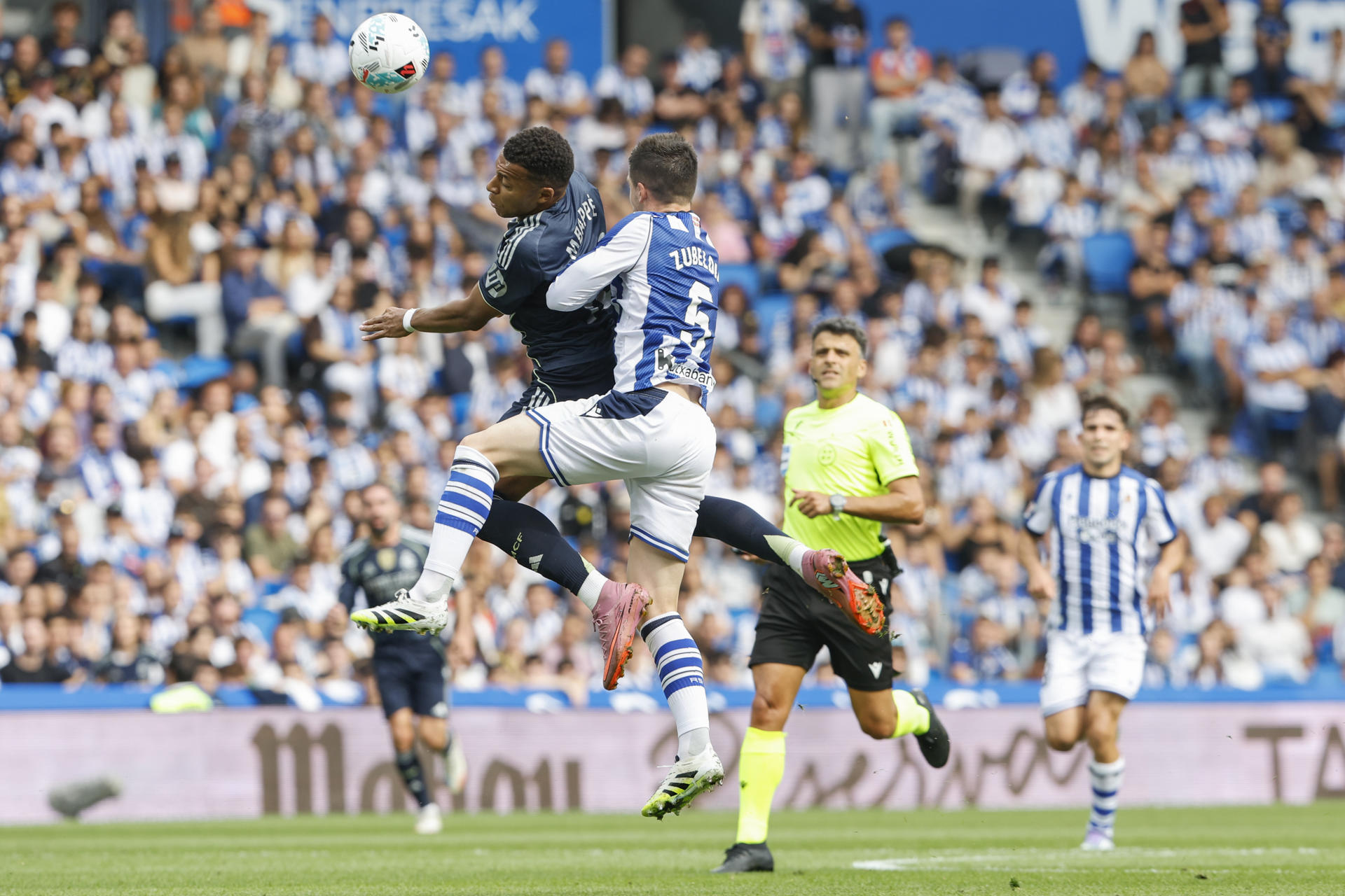 El delantero francés del Real Madrid, Kylian Mbappé, y el defensa de la Real Sociedad Zubeldia durante el partido de la jornada 4 de La Liga EA Sports este sábado en el estadio Municipal de Anoeta en San Senastián.- EFE/ Juan Herrero