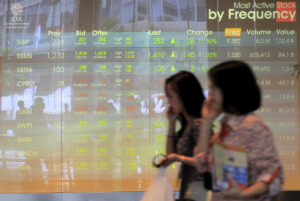 Imagen de archivo tomada el 25 de noviembre de 2024 que muestra a dos mujeres indonesias caminandoc erca de un monitor en la Bolsa de Yakarta. EPA/BAGUS INDAHONO
