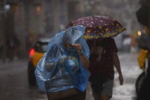 Personas se protegen de la lluvia en el centro de Barcelona. EFE/ Quique García