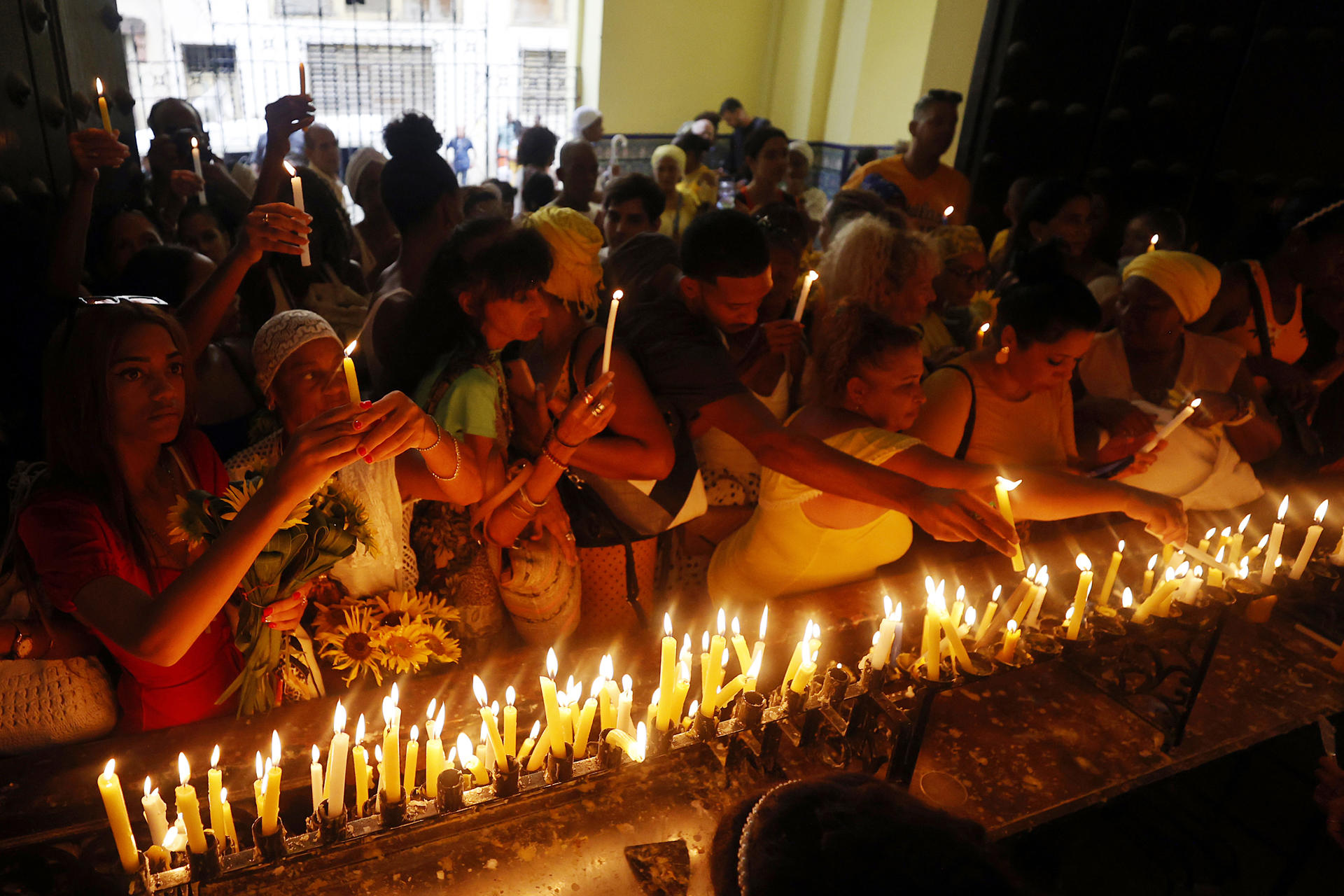 Personas encienden velas este lunes, en la iglesia Nuestra Señora de la Caridad en La Habana (Cuba). EFE/ Ernesto Mastrascusa