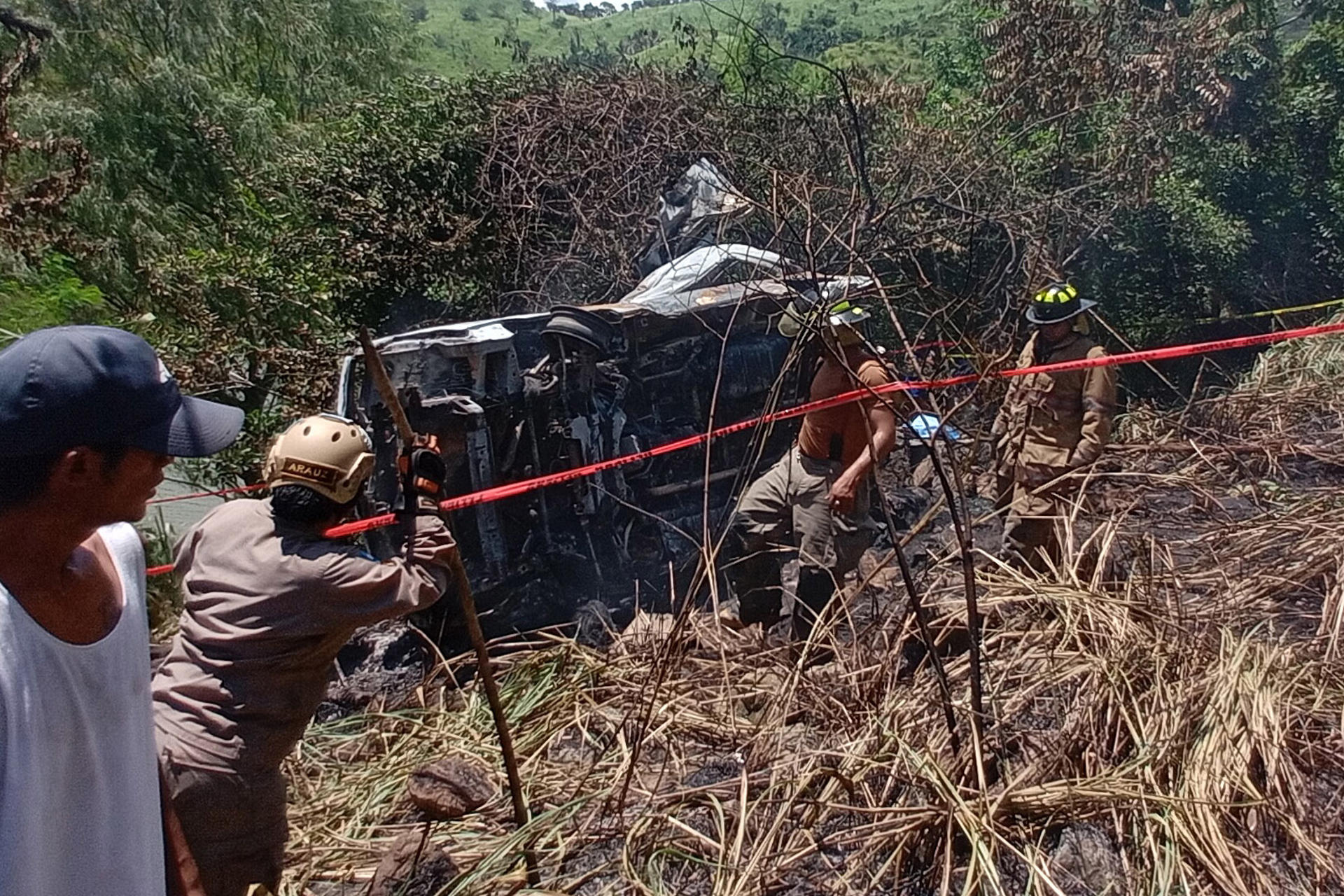 Integrantes del cuerpo de bomberos inspeccionan la zona donde un bus de transporte público, que cubría la ruta entre Cofradía y San Pedro Sula, se accidento este domingo, en la colonia Lempira en San Pedro Sula (Honduras). EFE/ José Valle