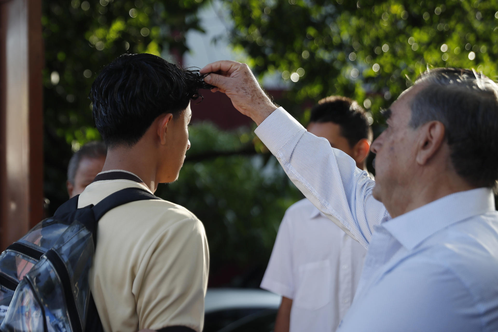 Un docente recibe a estudiantes del Instituto Nacional "General Manuel José Arce" este lunes, en San Salvador (El Salvador). EFE/Rodrigo Sura