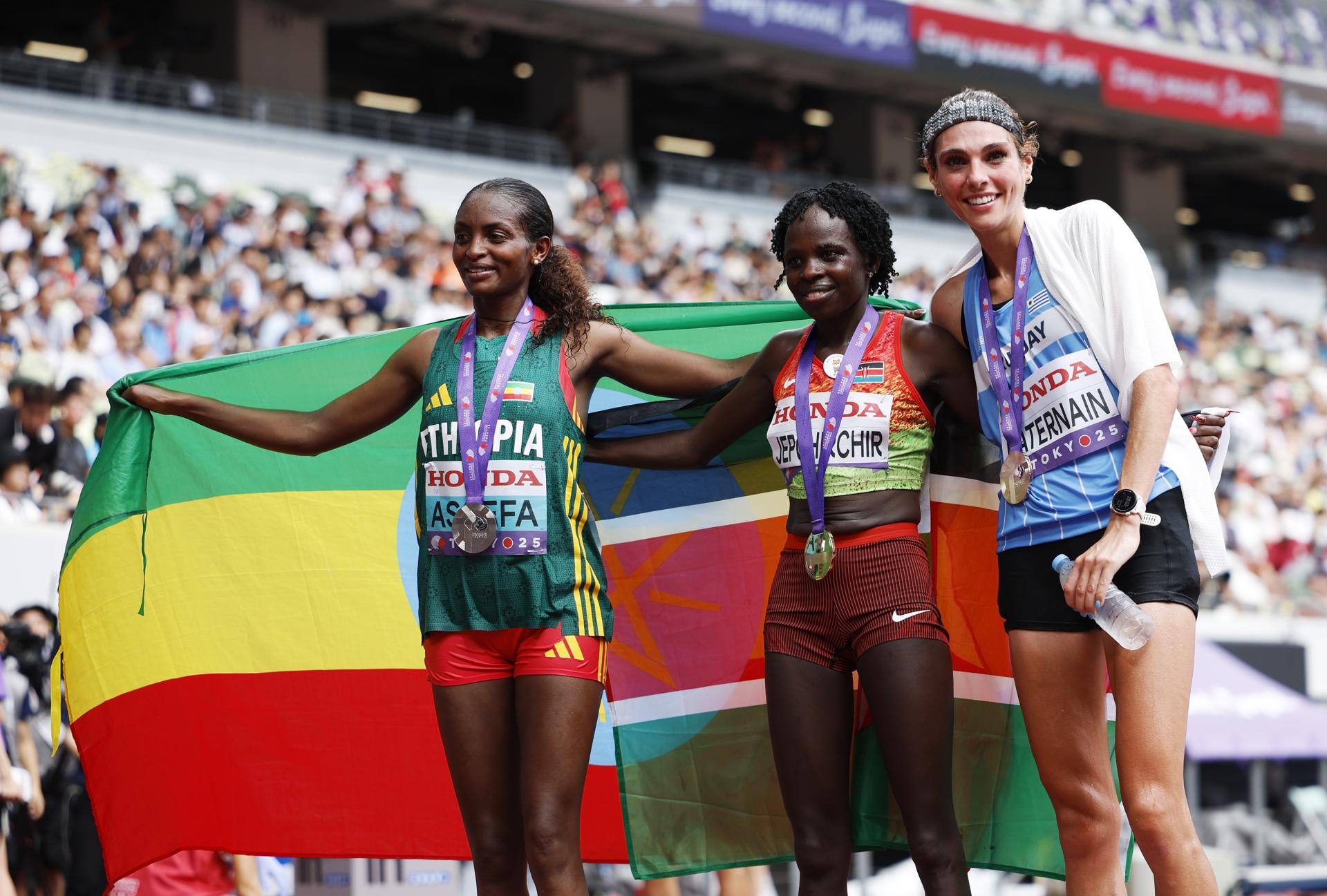 La ganadora de la medalla de oro Peres Jepchirchir (c), de Kenia, la ganadora de la presea de plata Tigst Assefa (i), de Etiopía, y Julia Paternain, de Uruguay, que logró el bronce en el maratón de los Mundiales de Atletismo de Tokio. EFE/EPA/FRANCK ROBICHON
