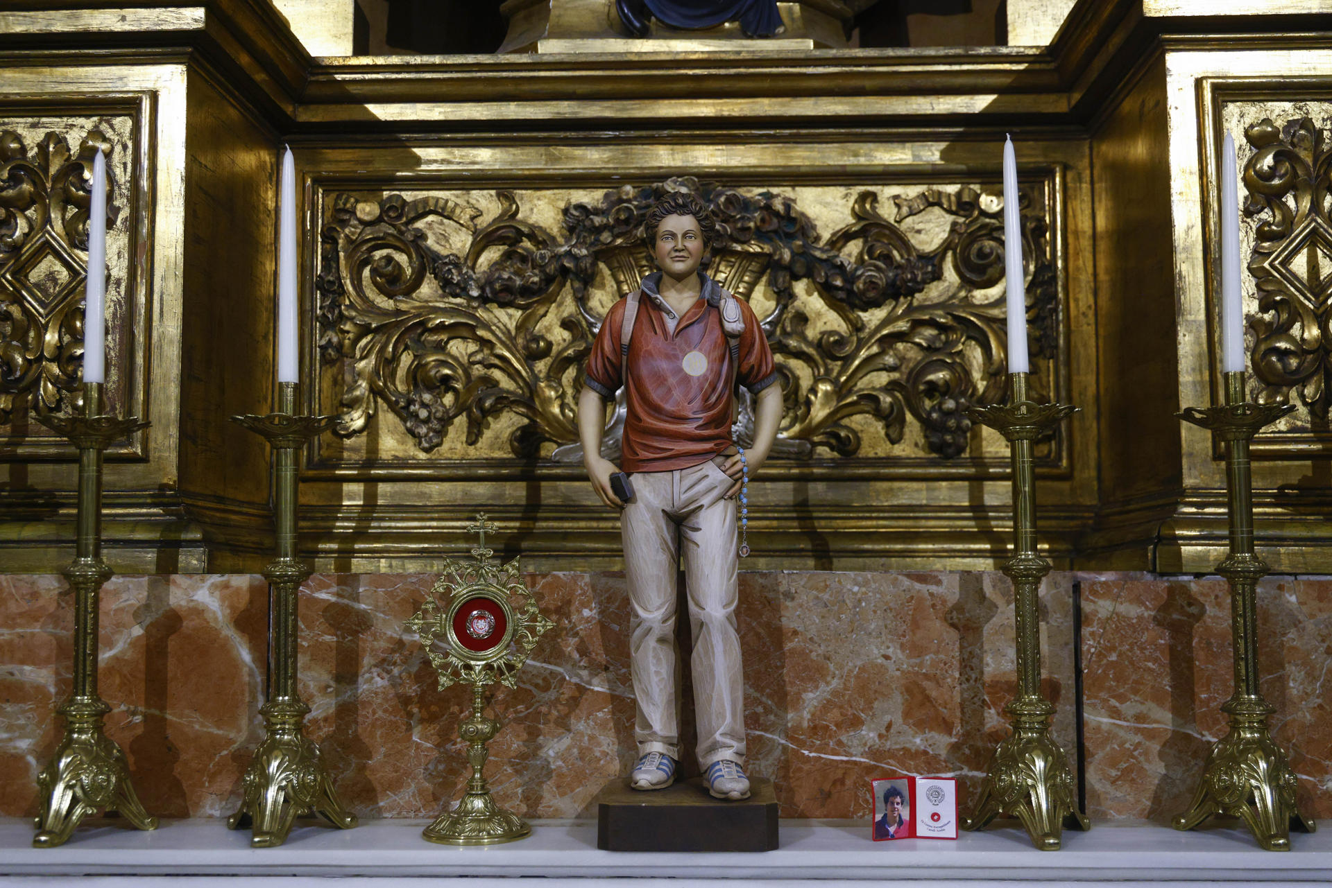 La imagen de Carlo Acutis, el beato conocido como 'el influencer de Dios', fallecido en 2006 con solo 15 años, y que este domingo se convertirá en el primer santo milenial de la historia, "ilumina" desde hace meses la basílica de la Mercè de Barcelona, donde ya cuenta con devotos, especialmente entre los más jóvenes. EFE/Quique García