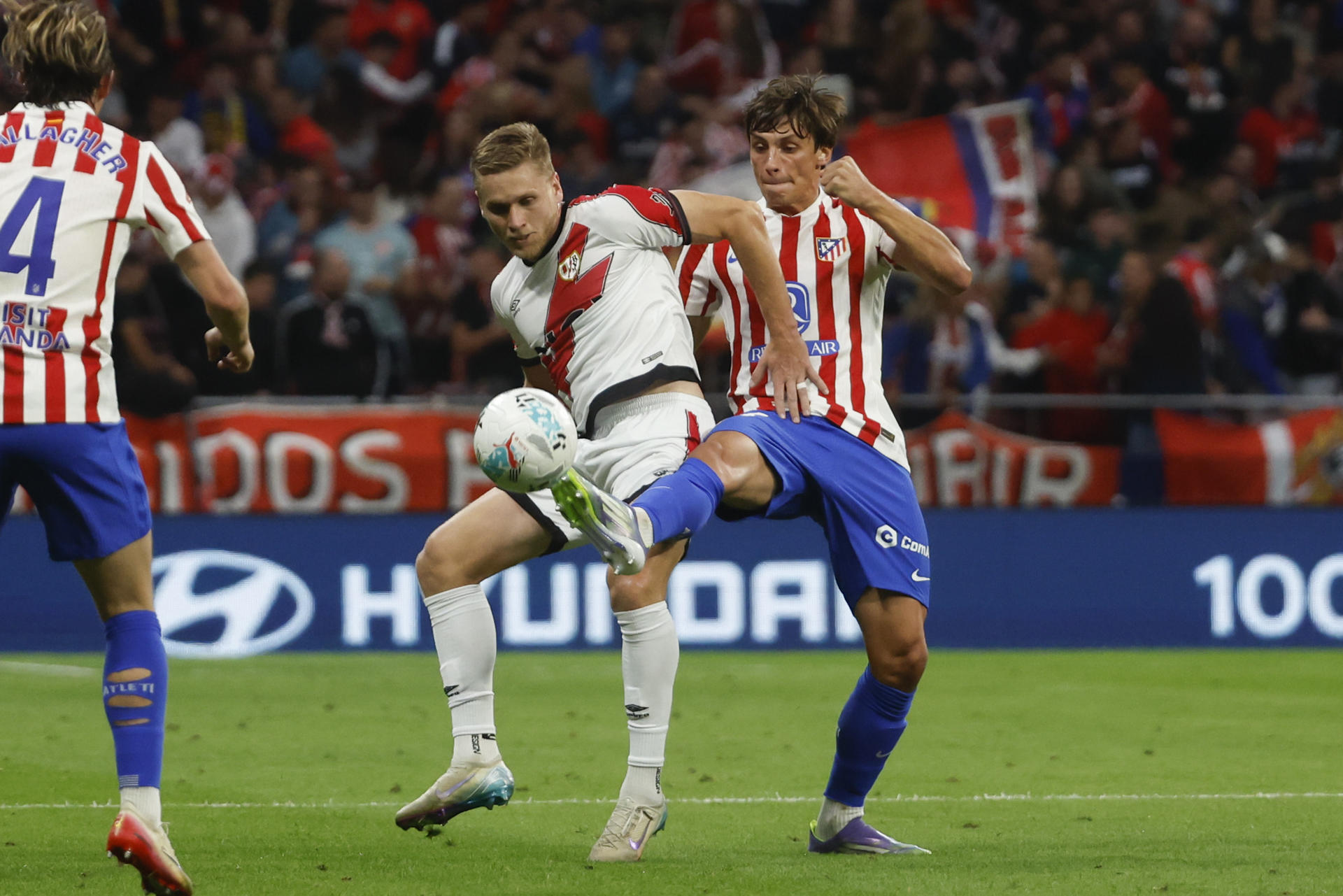 El defensa del Atlético de Madrid Le Normand (d) disputa el balón ante el defensa rumano del Rayo Vallecano Andrei Ratiu durante el partido de la jornada 6 de Liga que disputan en el estadio Riyadh Air Metropolitano, en Madrid. EFE/Juanjo Martín
