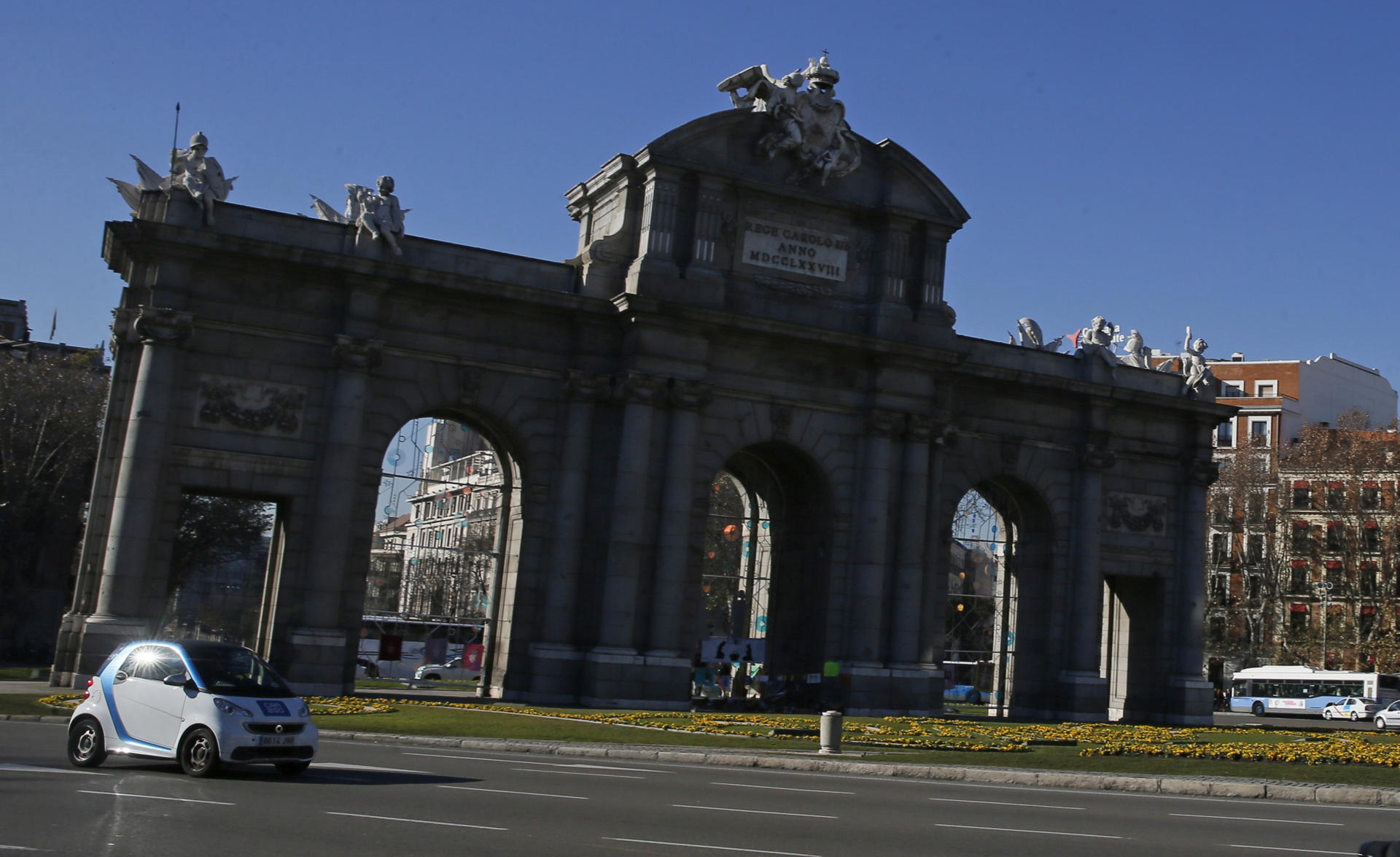 Imagen de archivo de Madrid con un coche de alquiler eléctrico a su paso por la Puerta de Alcalá. EFE/Fernando Alvarado