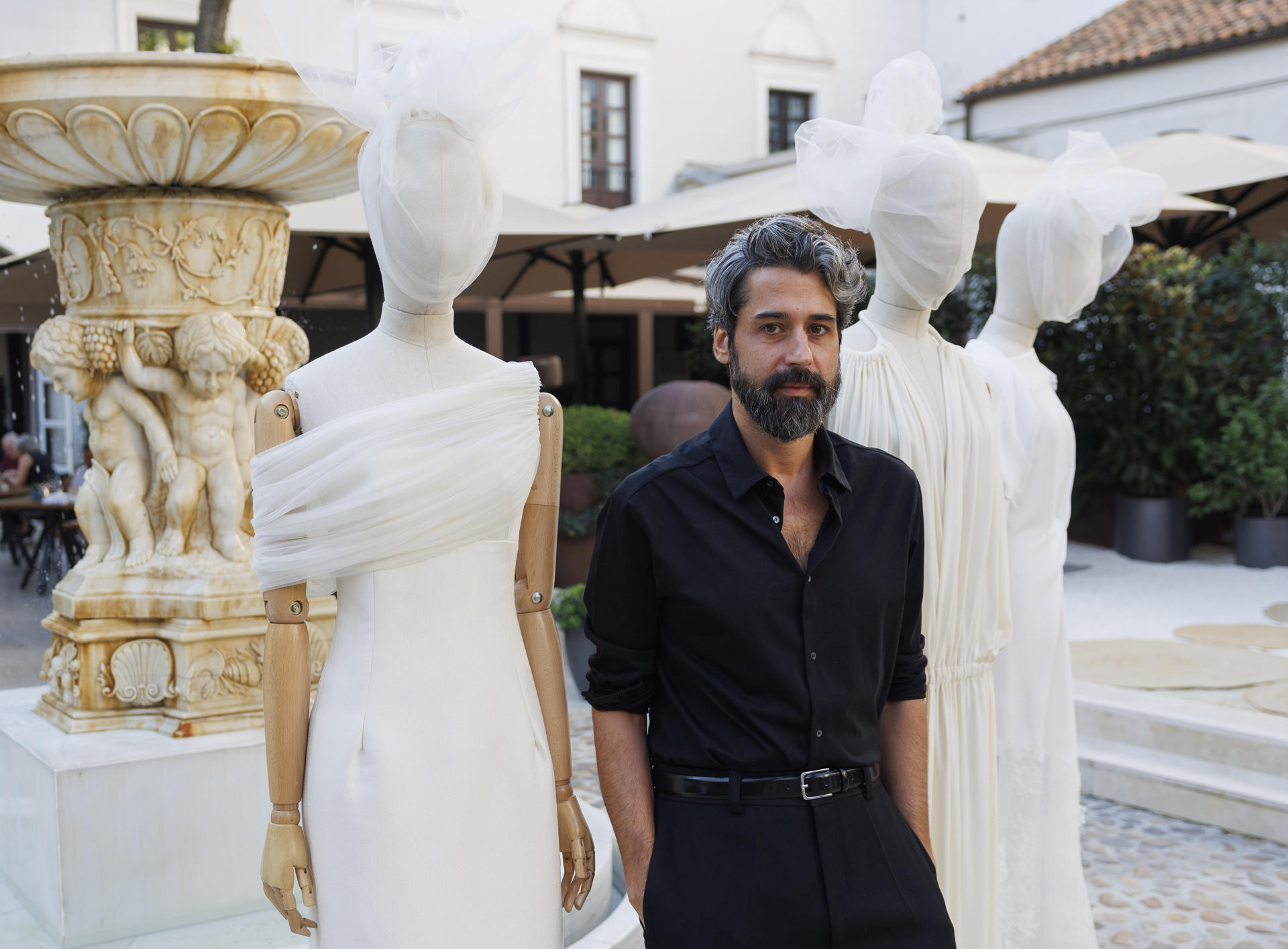 El diseñador Moisés Nieto posa junto a algunas de sus creaciones durante la presentación de su colección cápsula de vestidos de novia parte de Madrid es Moda, este lunes en Madrid. EFE/Sergio Pérez