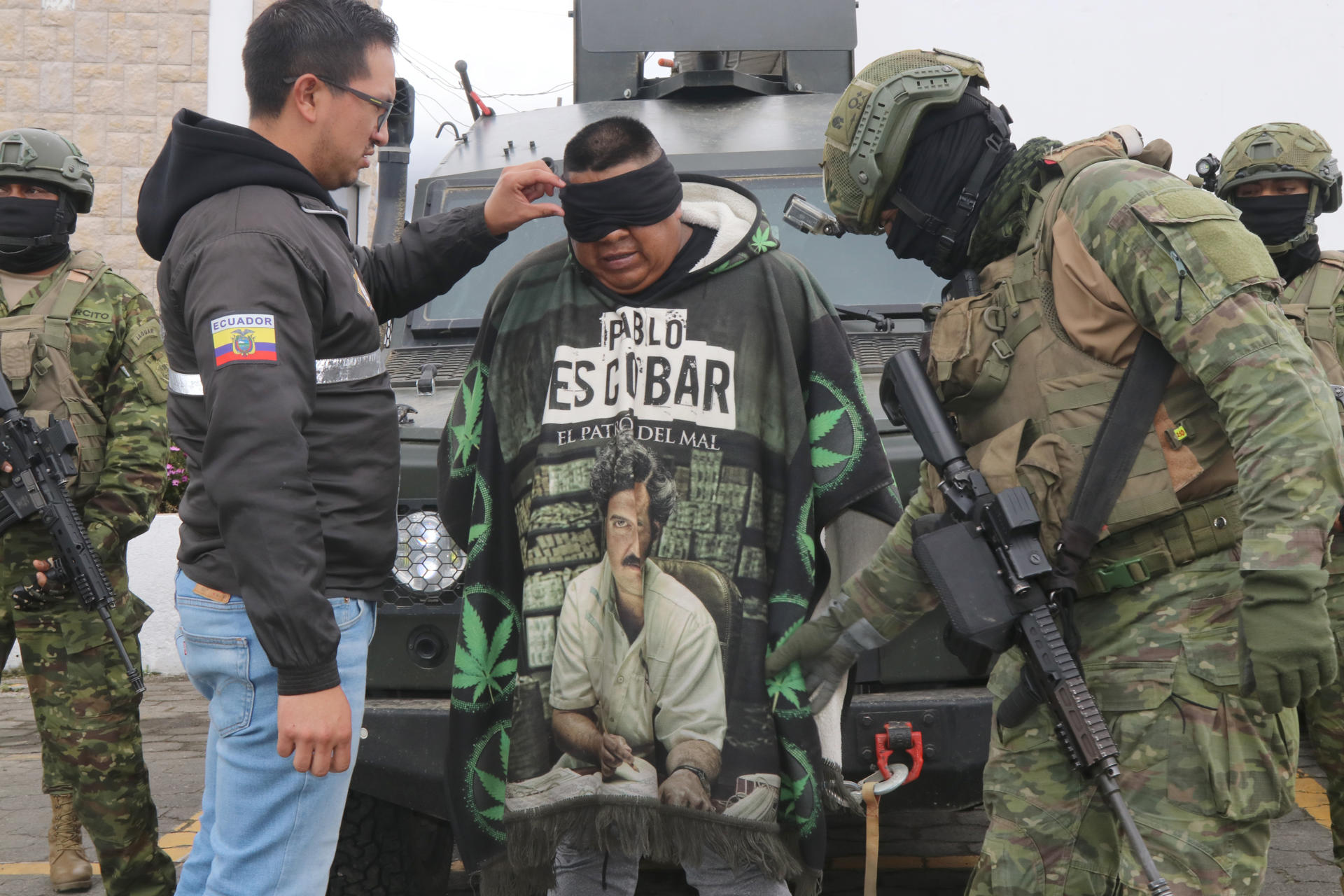 Uno de los presuntos cabecillas del Frente Iván Ríos, Ángel Polibio Q. Ch. es custodiado por integrantes de la Policía y del Ejército de Ecuador este sábado, en Tulcán (Ecuador). EFE/ Xavier Montalvo
