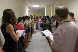 Varios opositores esperan a que se les llame antes de acceder al aula de examen en Sevilla. EFE/ David Arjona