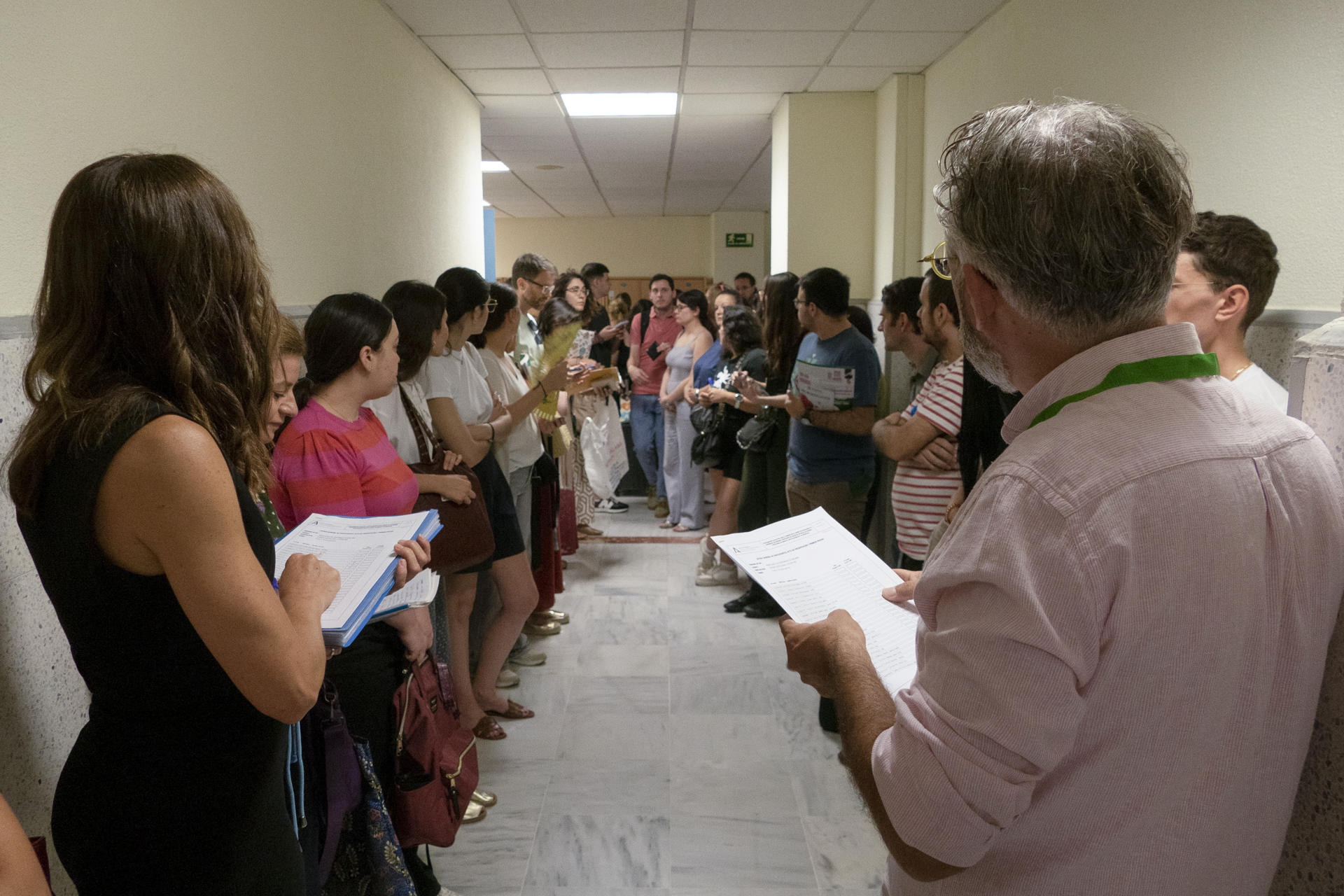 Varios opositores esperan a que se les llame antes de acceder al aula de examen en Sevilla. EFE/ David Arjona
