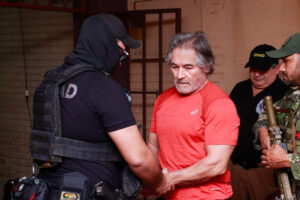 Fotografía cedida por la Secretaría Nacional Antidrogas de Paraguay que muestra el traslado del presunto líder del grupo criminal La Barredora, Hernán Bermúdez Requena, hacia el Aeropuerto Internacional Silvio Pettirossi este miércoles, en Asunción (Paraguay). EFE/ Secretaría Nacional Antidrogas De Paraguay