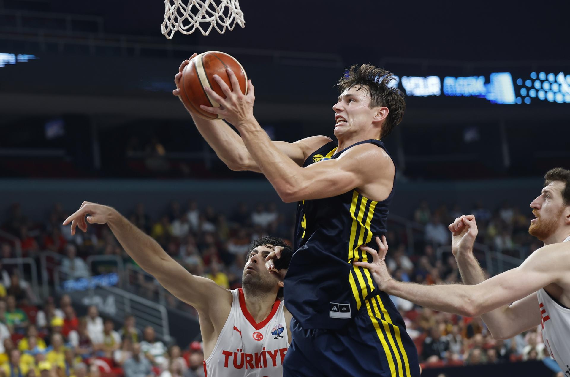 Ercan Osmani (d) y Furkan Korkmaz (i) de Turquía y Pelle Larsson de Suecia en acción durante el partido de baloncesto del EuroBasket 2025 entre Turquía y Suecia, en Riga, Letonia. EFE/EPA/TOMS KALNINS