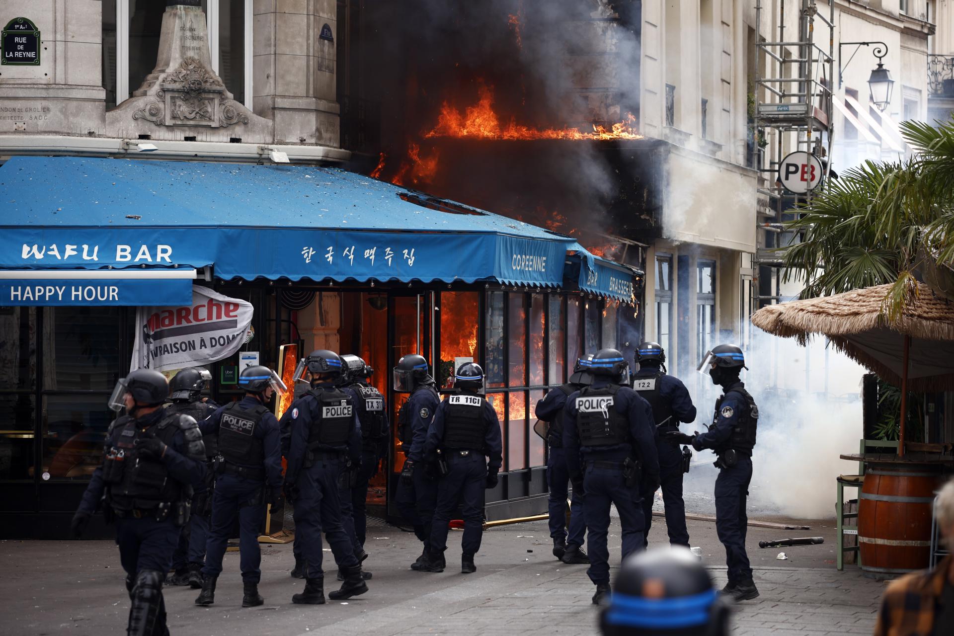 Agentes de policía crean este miércoles un perímetro alrededor de un incendio en un restaurante después de enfrentamientos con manifestantes durante las protestas contra las medidas de austeridad tras una llamada a la acción por el colectivo Bloquons tout (Bloqueemos Todo) en París. EFE/EPA/YOAN VALAT
