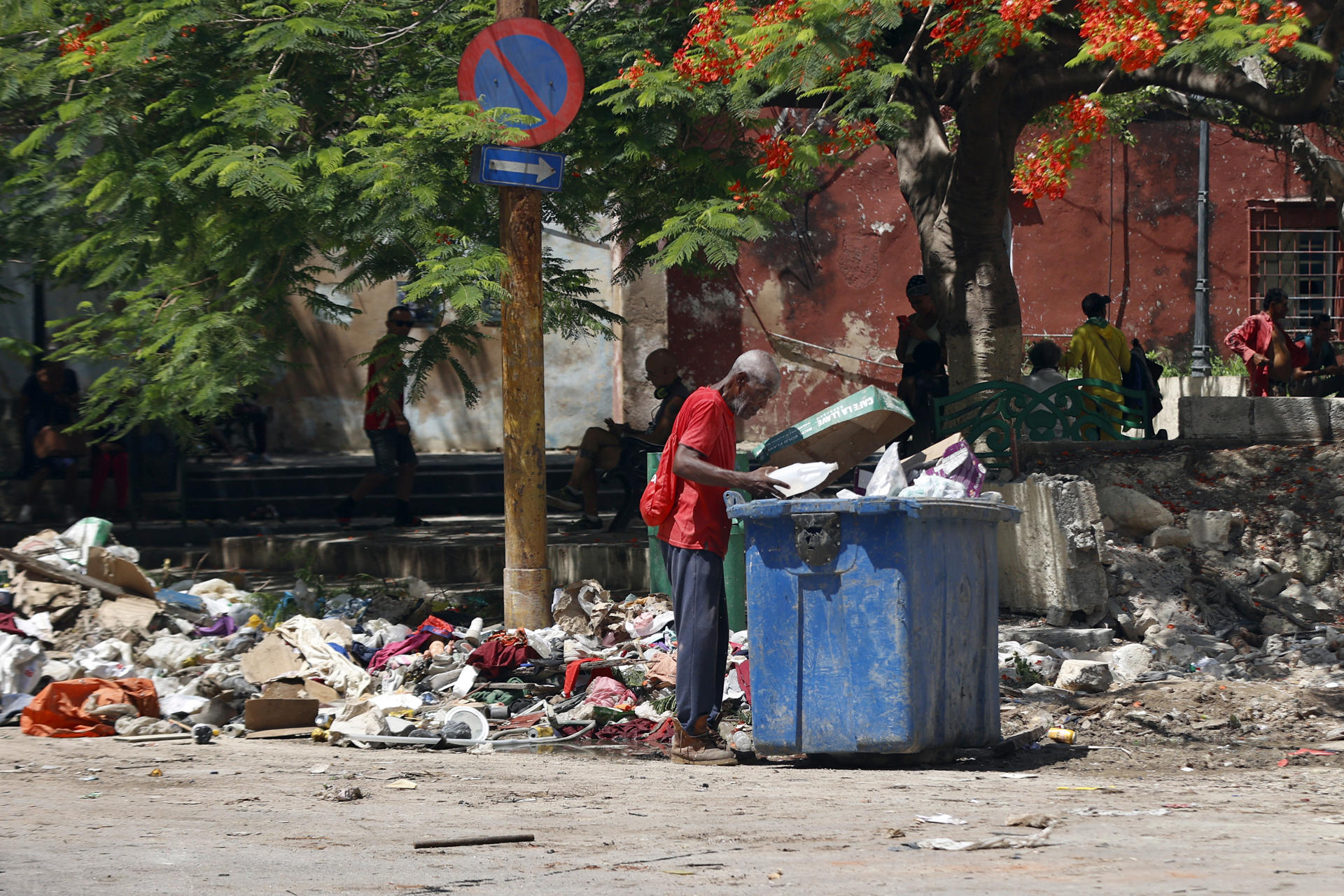 AME024. LA HABANA (CUBA), 16/09/2025.- Fotografía del 26 de agosto de 2025 que muestra a una persona revisando un contenedor de basura en La Habana (Cuba). Cuba, un país de 9,7 millones de habitantes, cuenta con más de 3,9 millones de viviendas de las que el 37 % se encuentran en regular o mal estado técnico, de acuerdo con cifras oficiales. EFE/ Ernesto Mastrascusa
