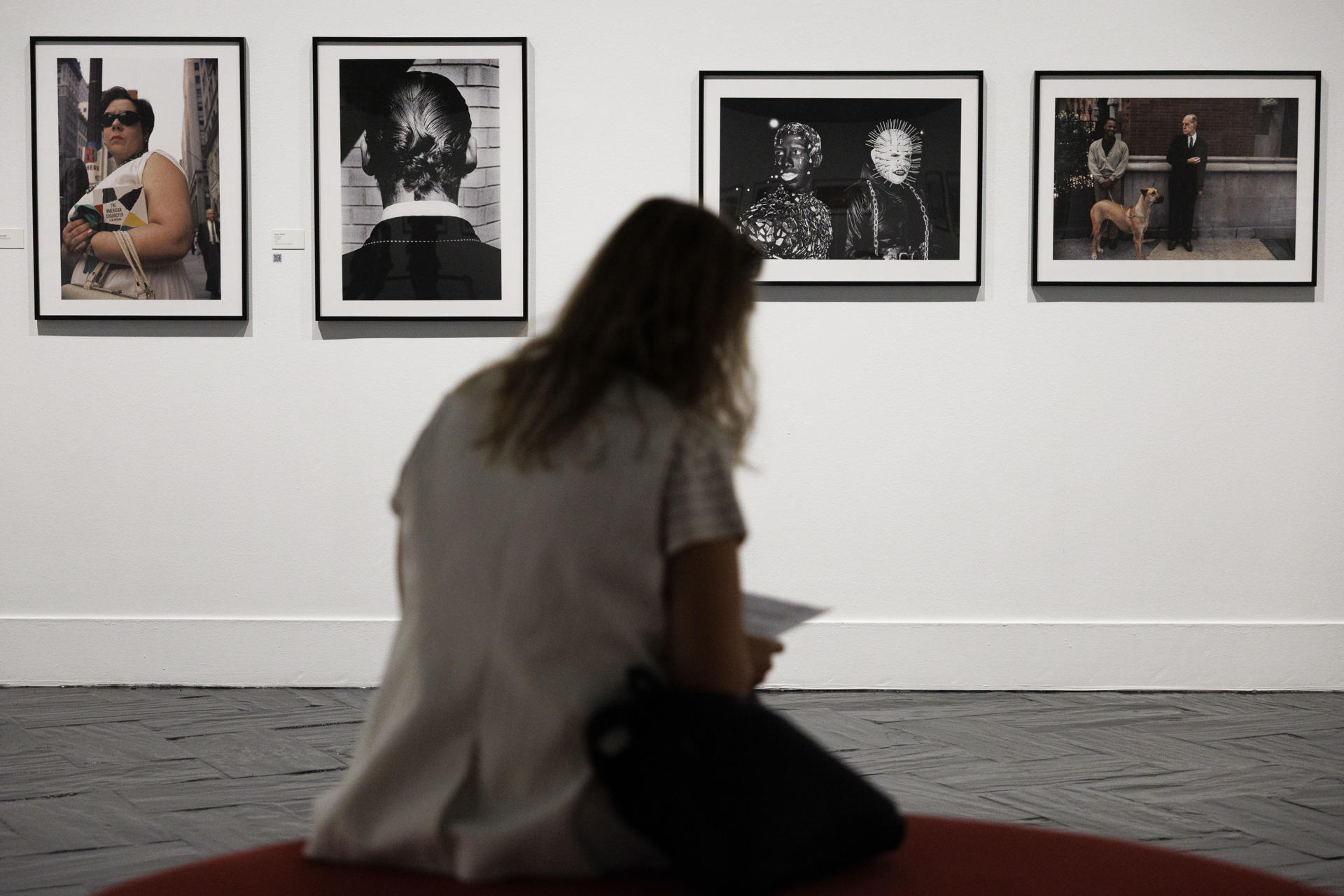 Una mujer lee un folleto durante la presentación de la Exposición "Leica. Un siglo de fotografía" en teatro madrileño Fernán Gómez, Centro Cultural de la Villa este martes.  La exposición, que permanecerá abierta al público del 10 de septiembre al 11 de enero de 2026, reúne 174 fotografías de los archivos de Leica de una selección de autores vinculados con la marca durante los siglos XX y XXI. EFE/Sergio Pérez
