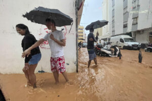 Personas caminan por calles anegadas en Ibiza debido a las intensas lluvias caídas este martes, que han dejado carreteras cortadas e inundaciones en distintos puntos de la isla y el desalojo preventivo y cierre de un colegio, aunque sin incidencias graves, según han informado desde diversas instituciones de la pitiusa mayor. Las Pitiusas han pasado a las 8 horas de este martes de alerta naranja a alerta amarilla por riesgo de lluvias, según informa la Agencia Estatal de Meteorología (Aemet), y durante la mañana las precipitaciones continúan siendo intensas sobre la isla de Ibiza.-EFE/ Sergio G. Cañizares