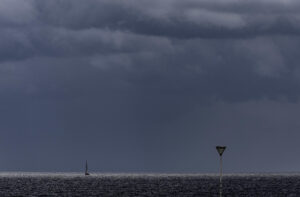 Un pequeño velero navega este jueves junto a la playa de La Zurriola de San Sebastián. EFE/Javier Etxezarreta