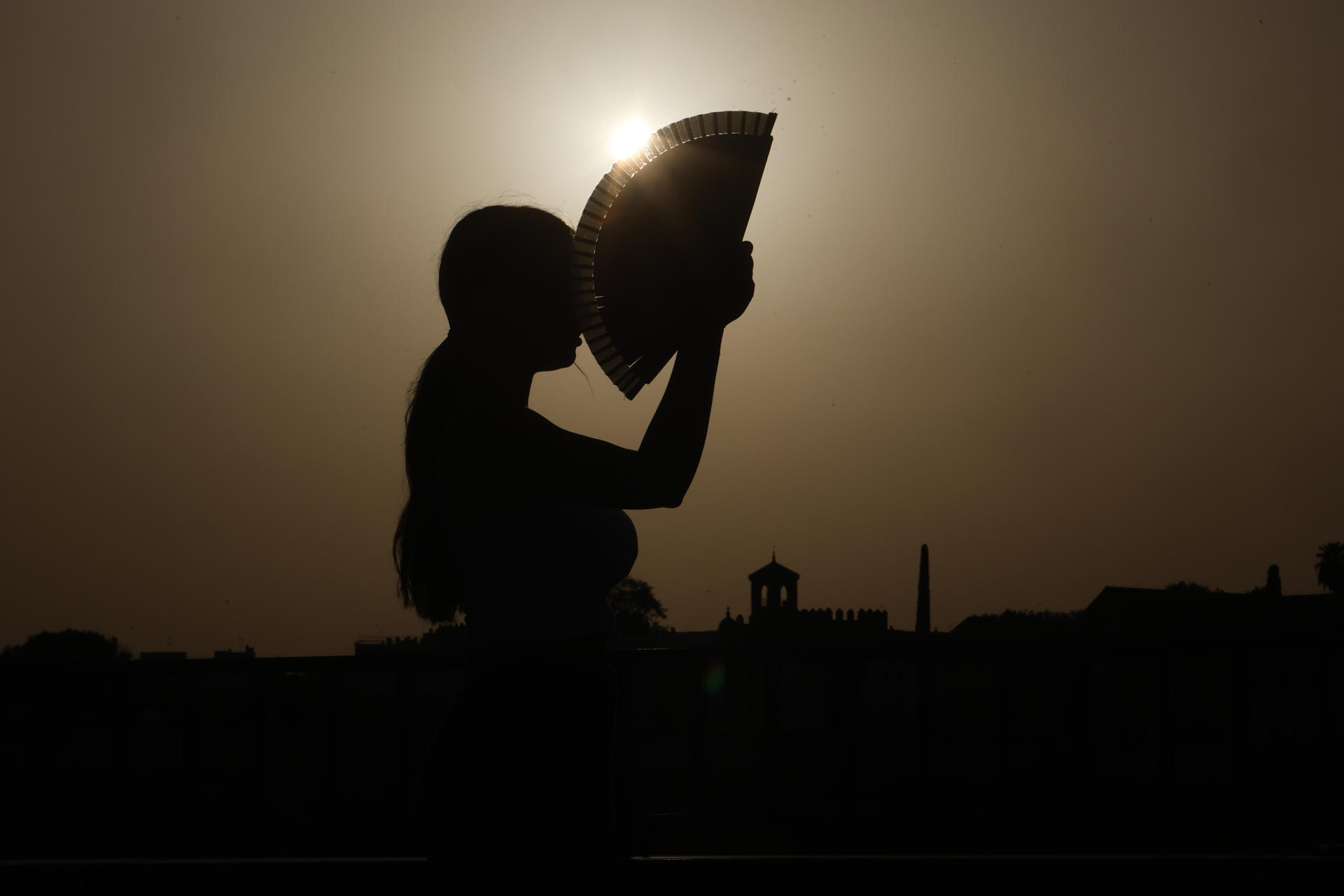 Una persona se abanica al atardecer en una jornada de altas temperaturas en la ciudad de Córdoba, en una fotografía de archivo. EFE/Salas
