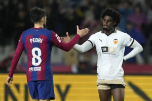 Foto de archivo del defensa del Valencia Thierry Rendall junto al barcelonista Pedri. EFE/Enric Fontcuberta.