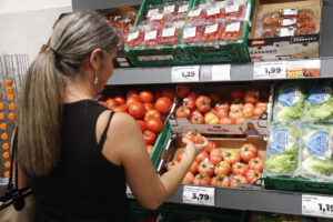 Una mujer comprando tomates en una tienda en Madrid. EFE/ MARIO MORÓN