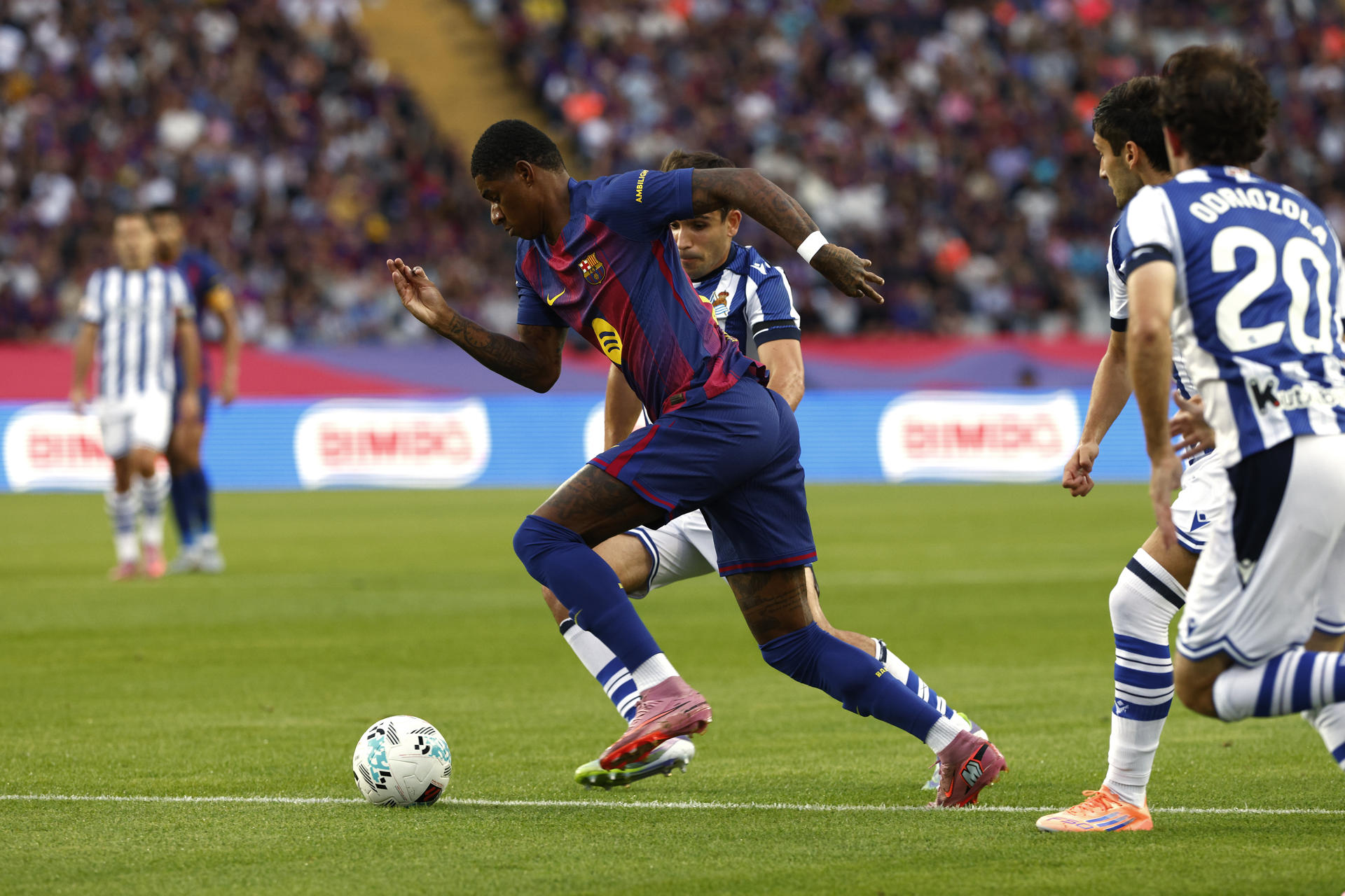 El delantero británico del FC Barcelona, Marcus Rashford, se lleva el balón ante los jugadores de la Real Sociedad durante el encuentro correspondiente a la séptima jornada de Liga EA Sports que FC Barcelona y Real Sociedad disputaron en el estadio de Montjuic, en Barcelona. EFE/Quique García.
