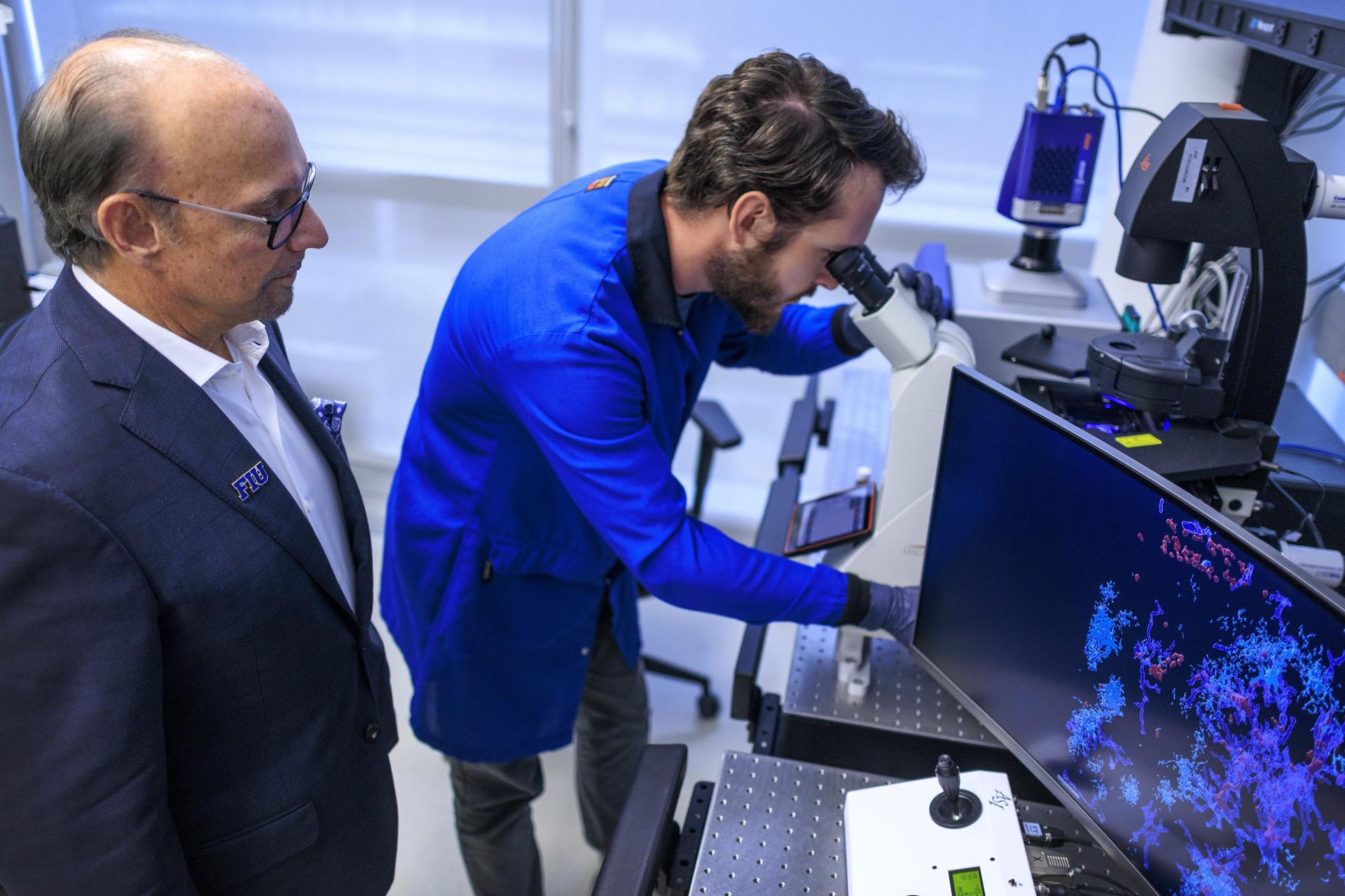 El decano de la Robert Stempel College of Public Health & Social Work de la Universidad Internacional de Florida, el doctor Tomas R. Guilarte (i), instruye a un técnico de laboratorio sobre las imágenes de muestras de tejido cerebral con la mutación Paisa, en su laboratorio de la Universidad, en Miami (Florida, EE.UU.). EFE/Cristóbal Herrera