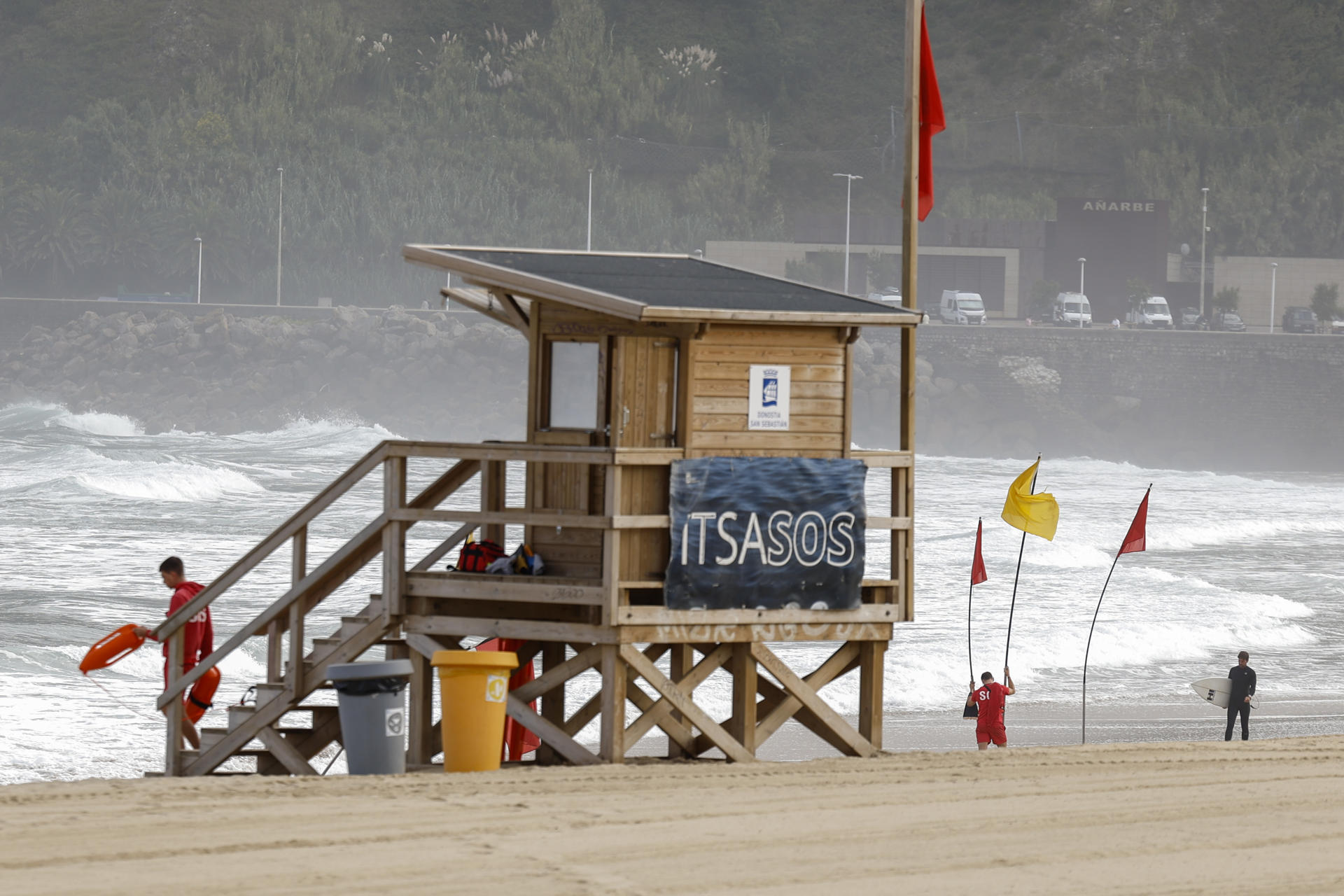 Unos socorristas señalizan la zona de baño este lunes en la playa de la Zurriola de San Sebastián. EFE/Juan Herrero
