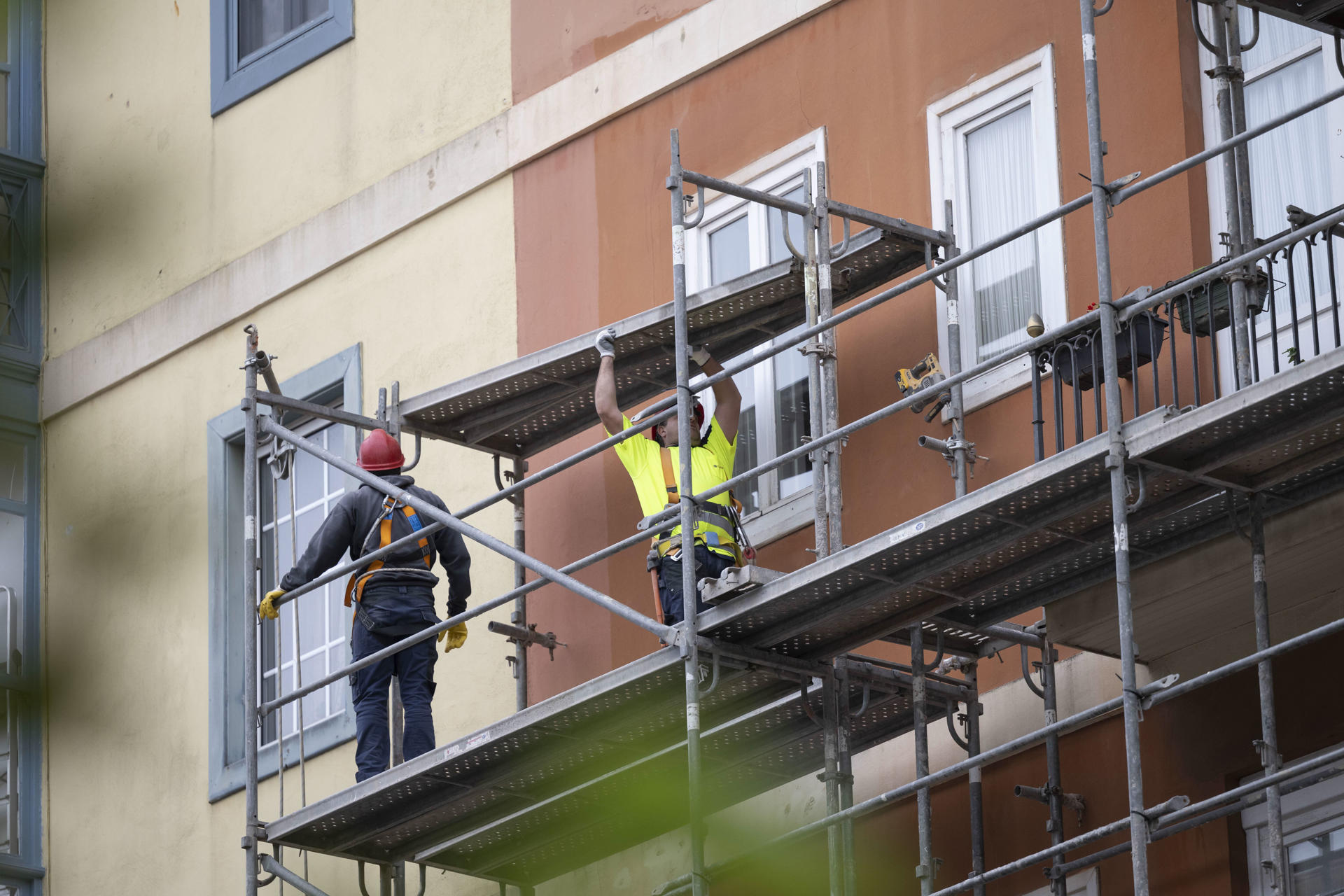 Dos trabajadores montan un andamio en una obra en una calle de Santander. EFE/ Pedro Puente Hoyos