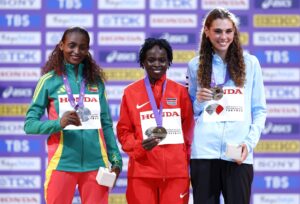 Las medallistas del maratón de los Mundiales de Atletismo de Tokio posan en la ceremonia de premiación: la ganadora de la presea de plata Tigst Assefa (i), de Etiopía; la ganadora del oro Peres Jepchirchir (c), de Kenia; y la uruguaya que se llevó el bronce, Julia Paternain. EFE/EPA/KIYOSHI OTA