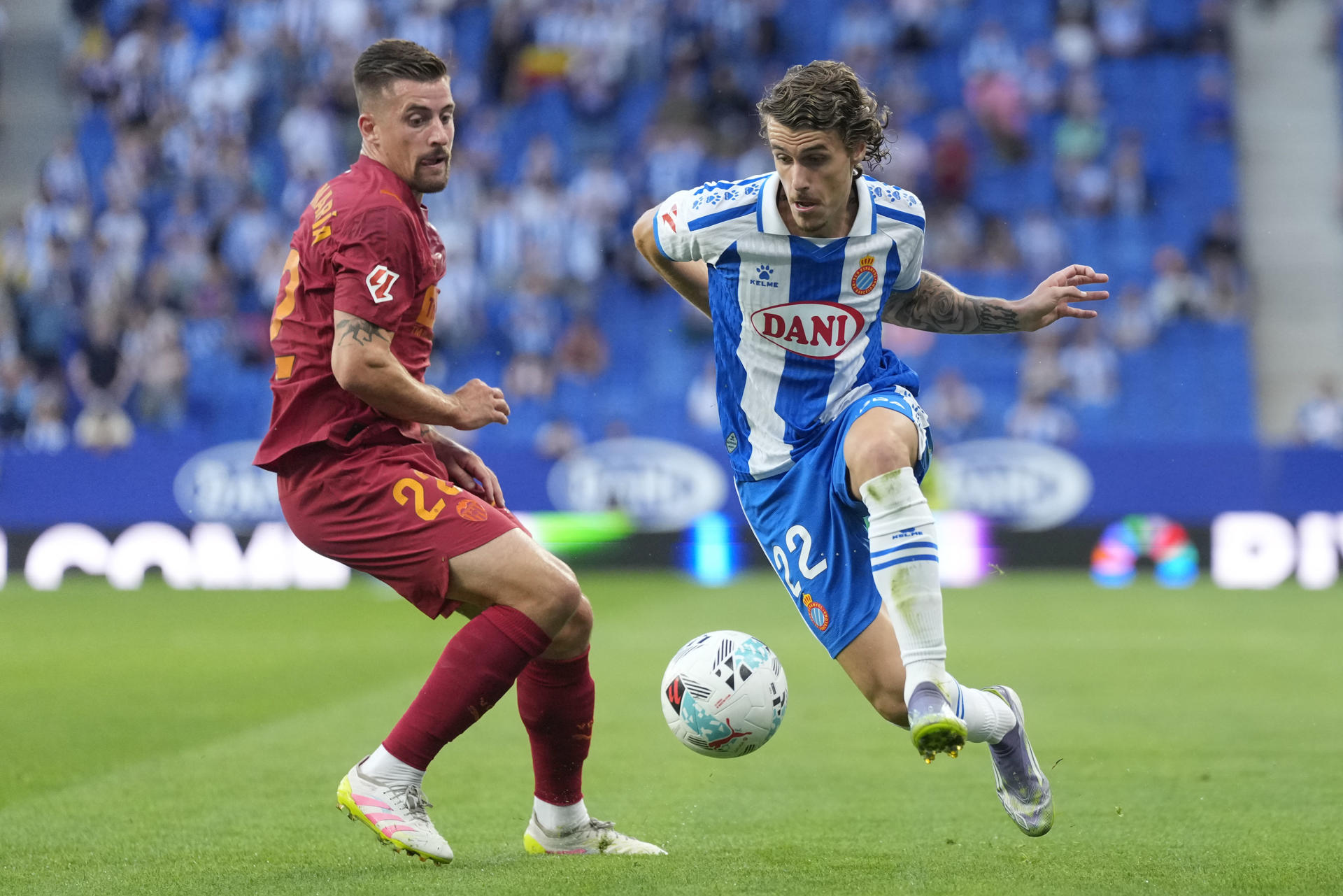 El defensa del Espanyol Carlos Romero (d) controla el balón ante Baptiste Santamaría, del Valencia, durante el encuentro correspondiente a la sexta jornada de LaLiga EA Sports disputado entre el RCD Espanyol y el Valencia CF en el RCDE Stadium en Barcelona, este martes. EFE/Enric Fontcuberta
