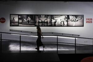 Una mujer recorre una sala durante la presentación de la Exposición "Leica. Un siglo de fotografía" en teatro madrileño Fernán Gómez, Centro Cultural de la Villa este martes.  La exposición, que permanecerá abierta al público del 10 de septiembre al 11 de enero de 2026, reúne 174 fotografías de los archivos de Leica de una selección de autores vinculados con la marca durante los siglos XX y XXI. EFE/Sergio Pérez